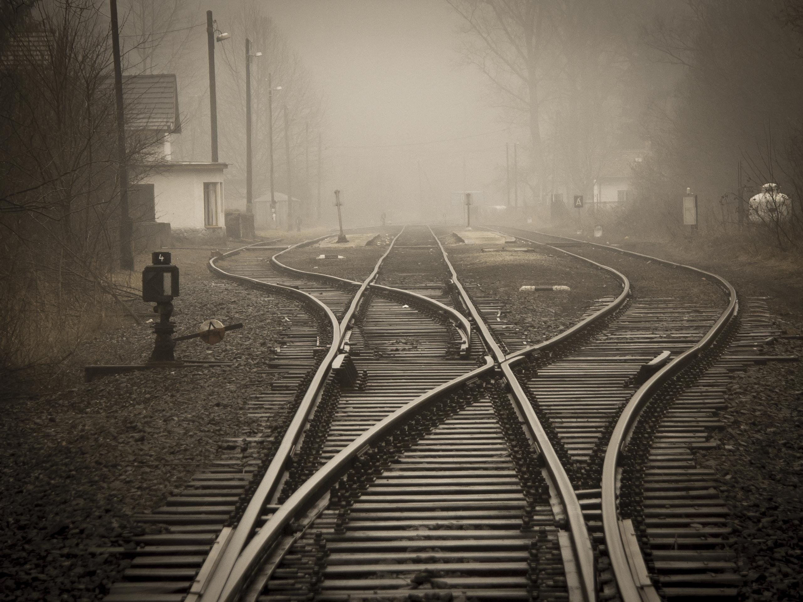 Pictured - An image of railroad tracks in a foggy city | Source: Pexels 