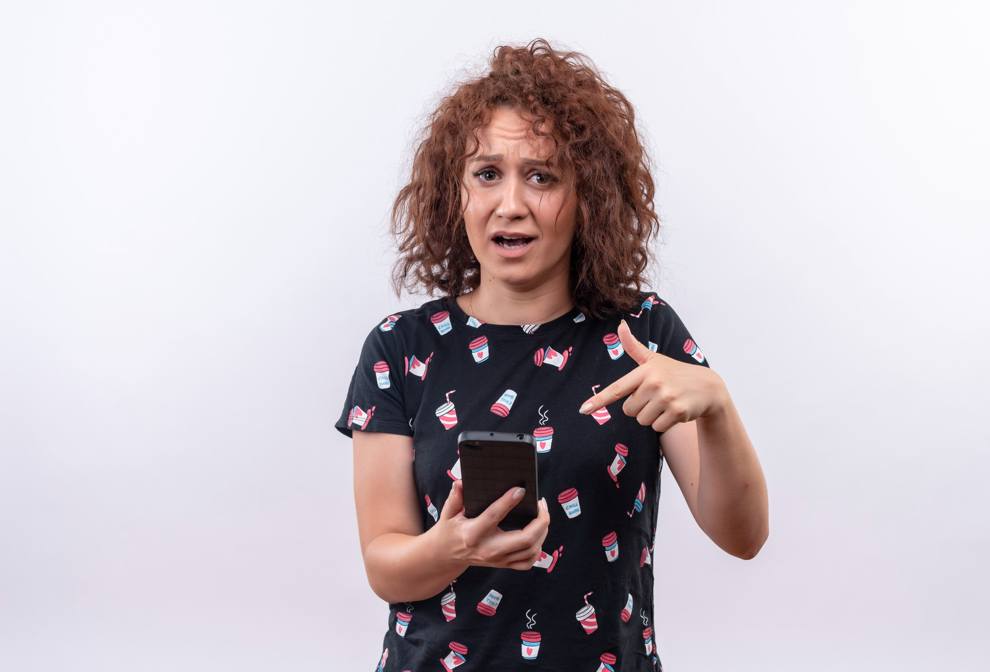 A distressed woman pointing at her phone | Source: Freepik