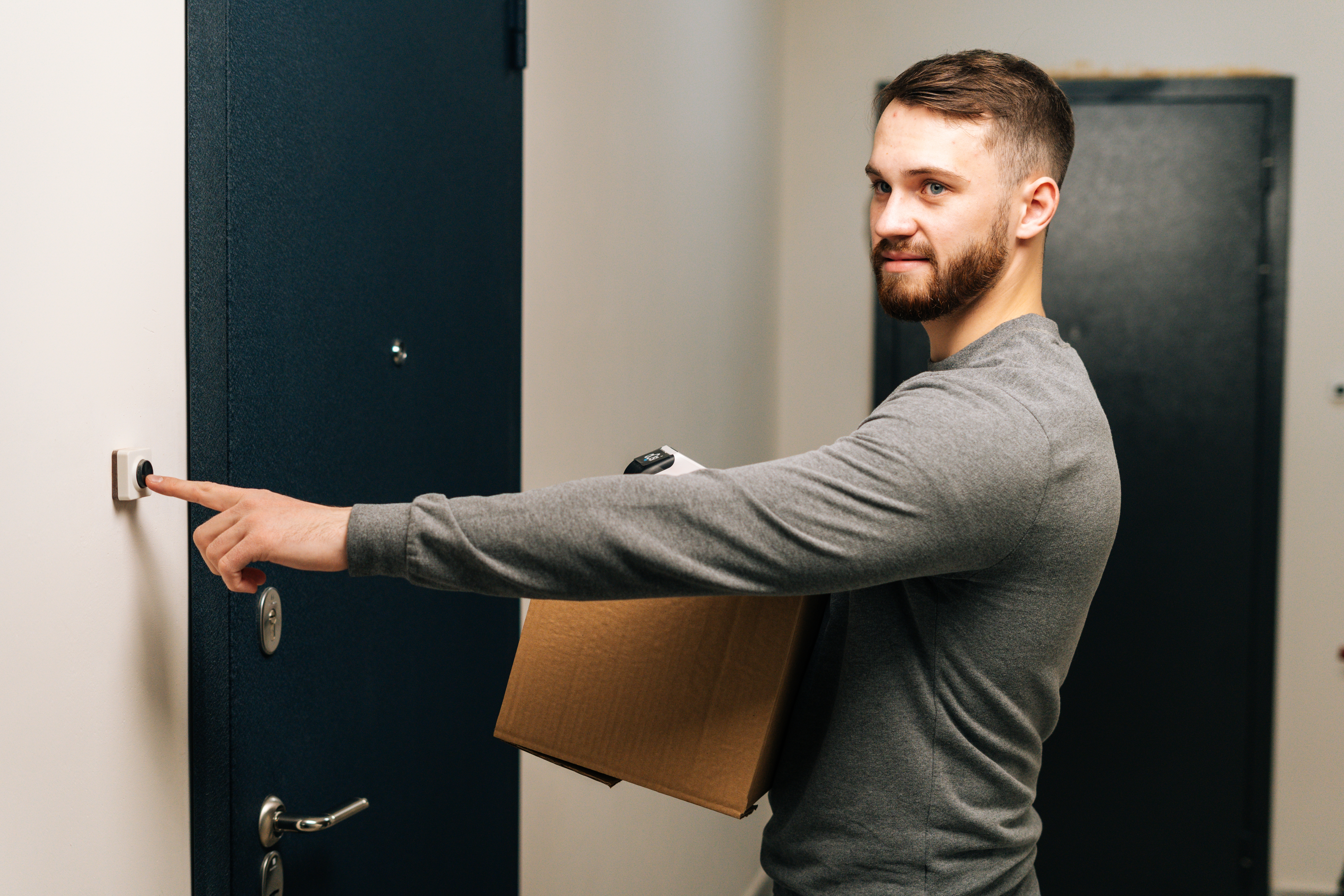 A delivery man ringing doorbell at a customer's apartment | Source: Shutterstock