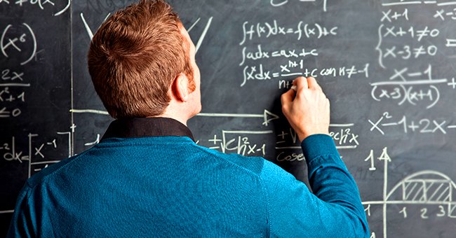 Ein Lehrer schreibt etwas an die Tafel. | Quelle: Shutterstock