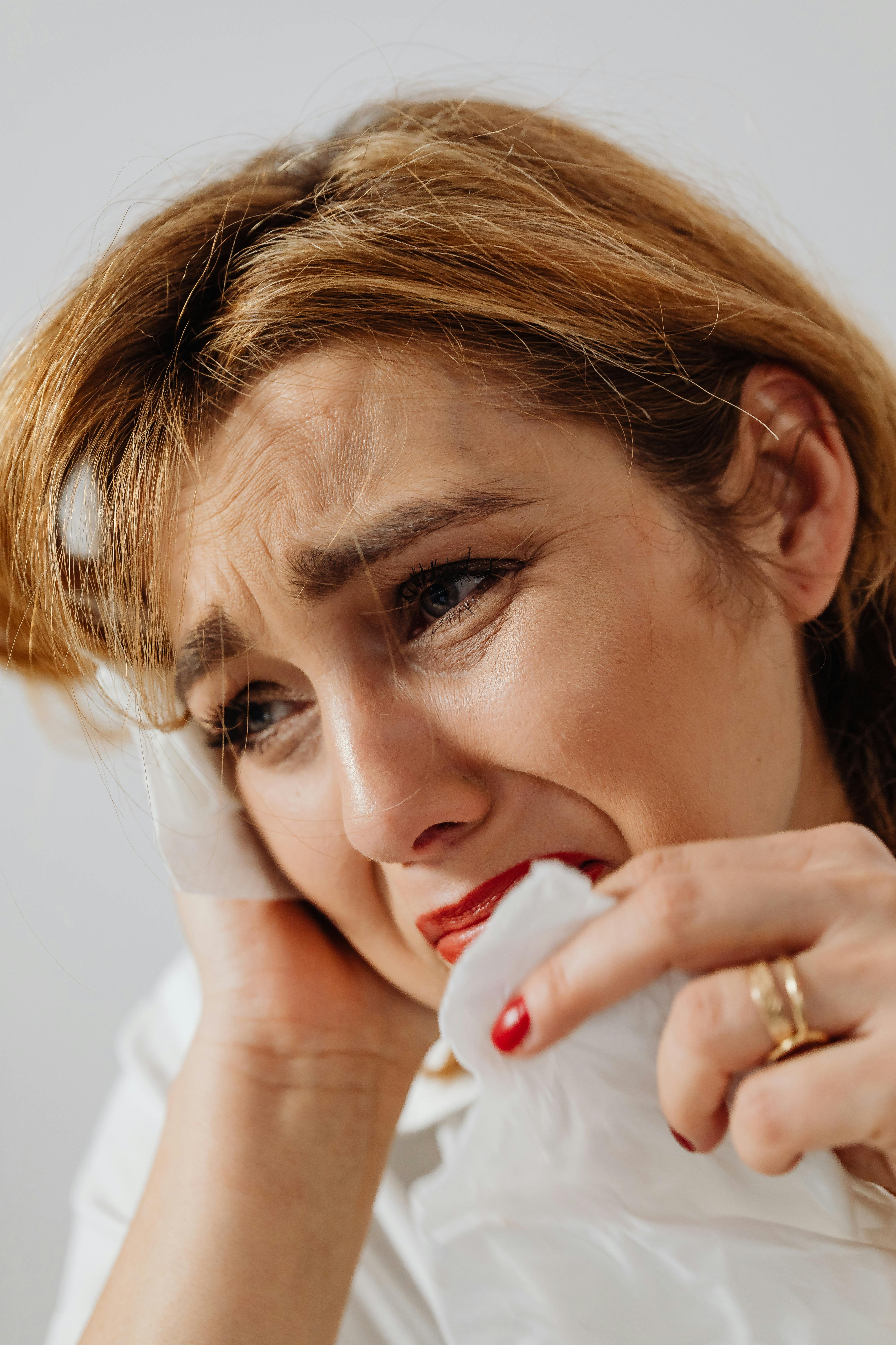 A close-up of a sad woman holding a tissue | Source: Pexels