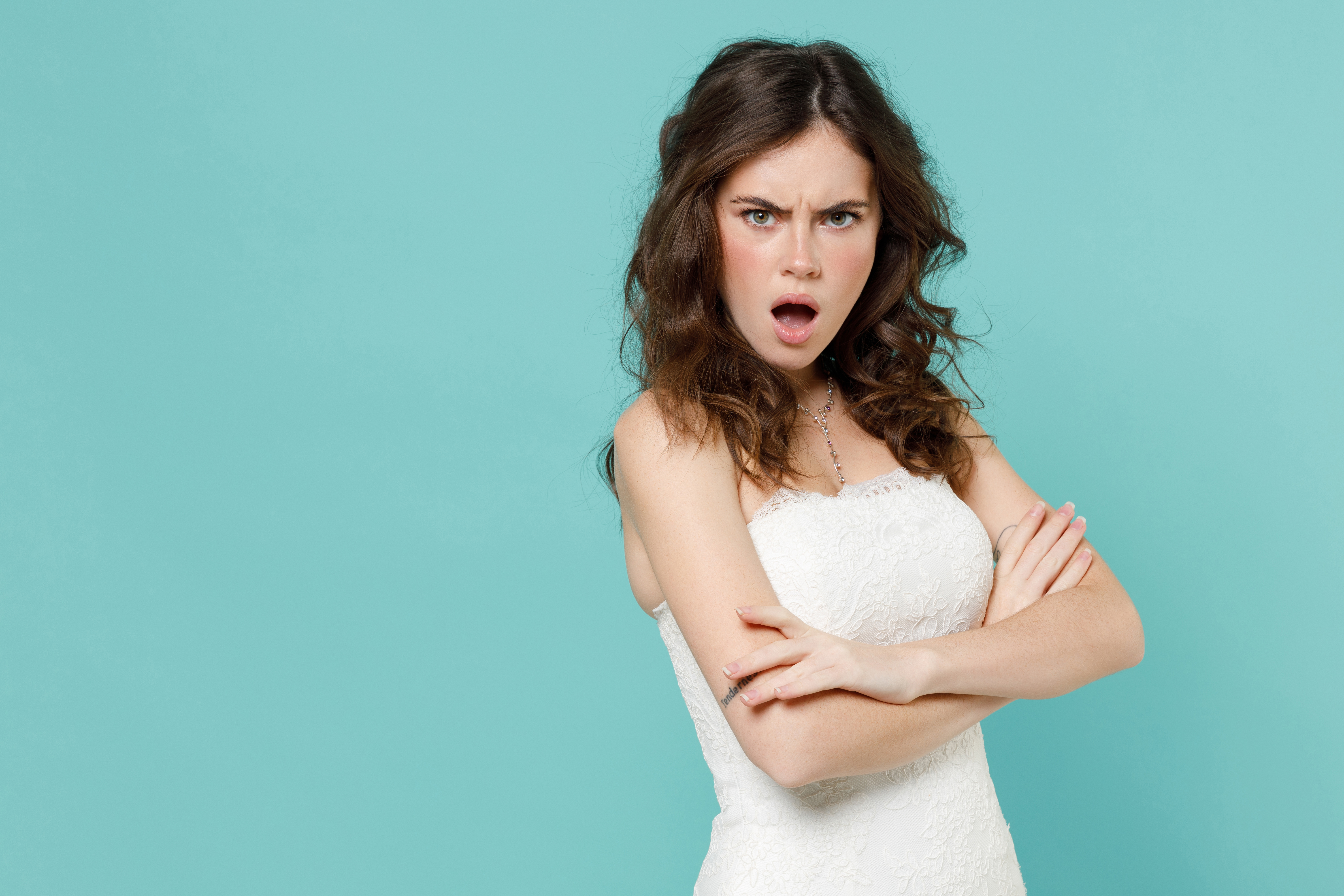 An angry bride standing with her arms folded on her chest | Source: Shutterstock