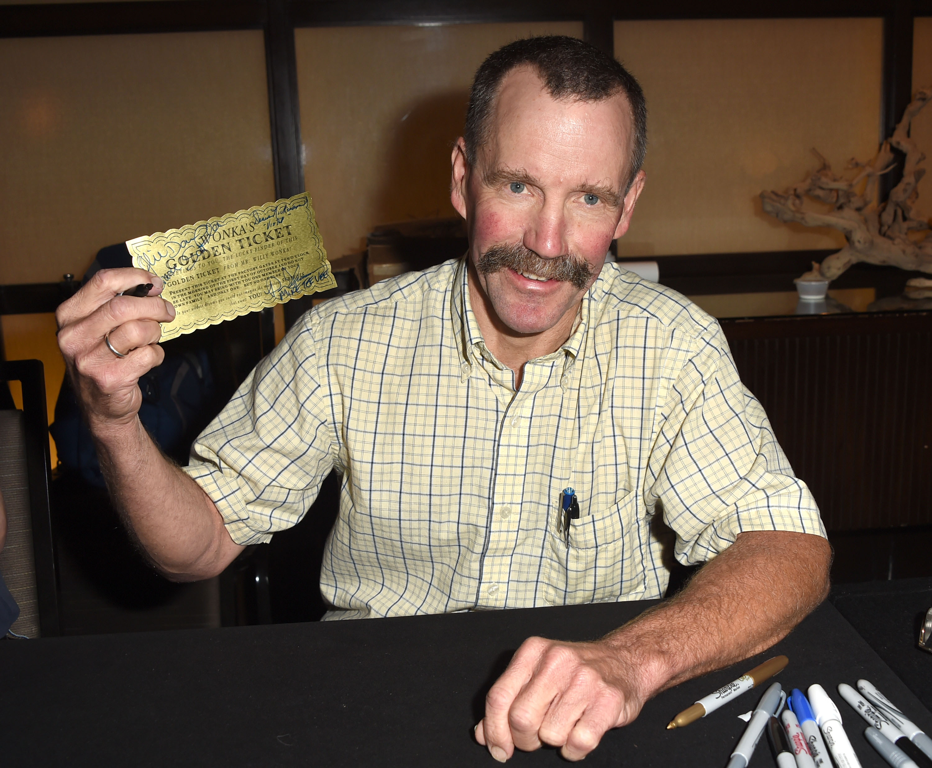 Peter Ostrum posing with a warm smile at The Hollywood Show while holding a golden ticket. | Source: Getty Images