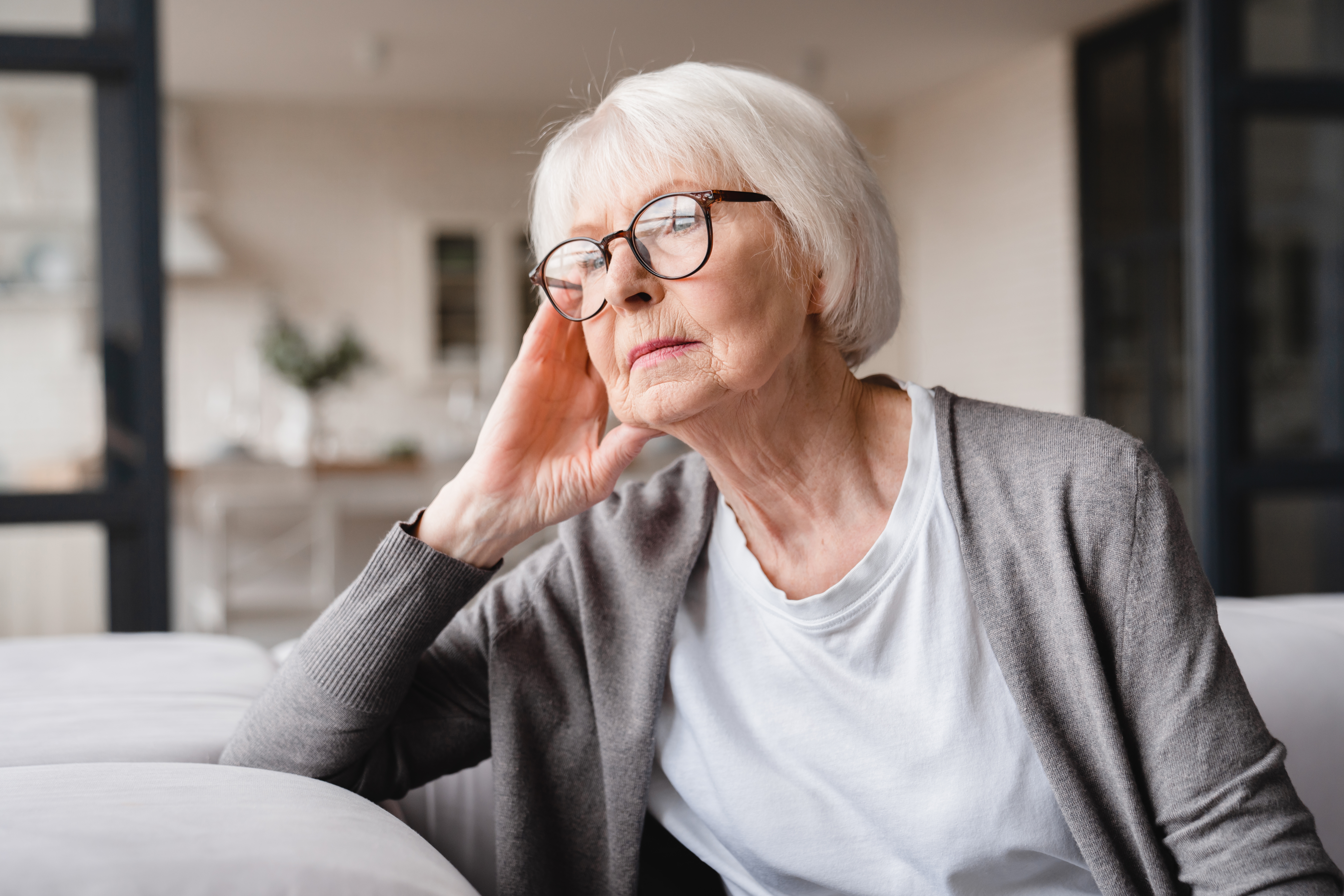 An older woman sitting on a couch | Source: Shutterstock