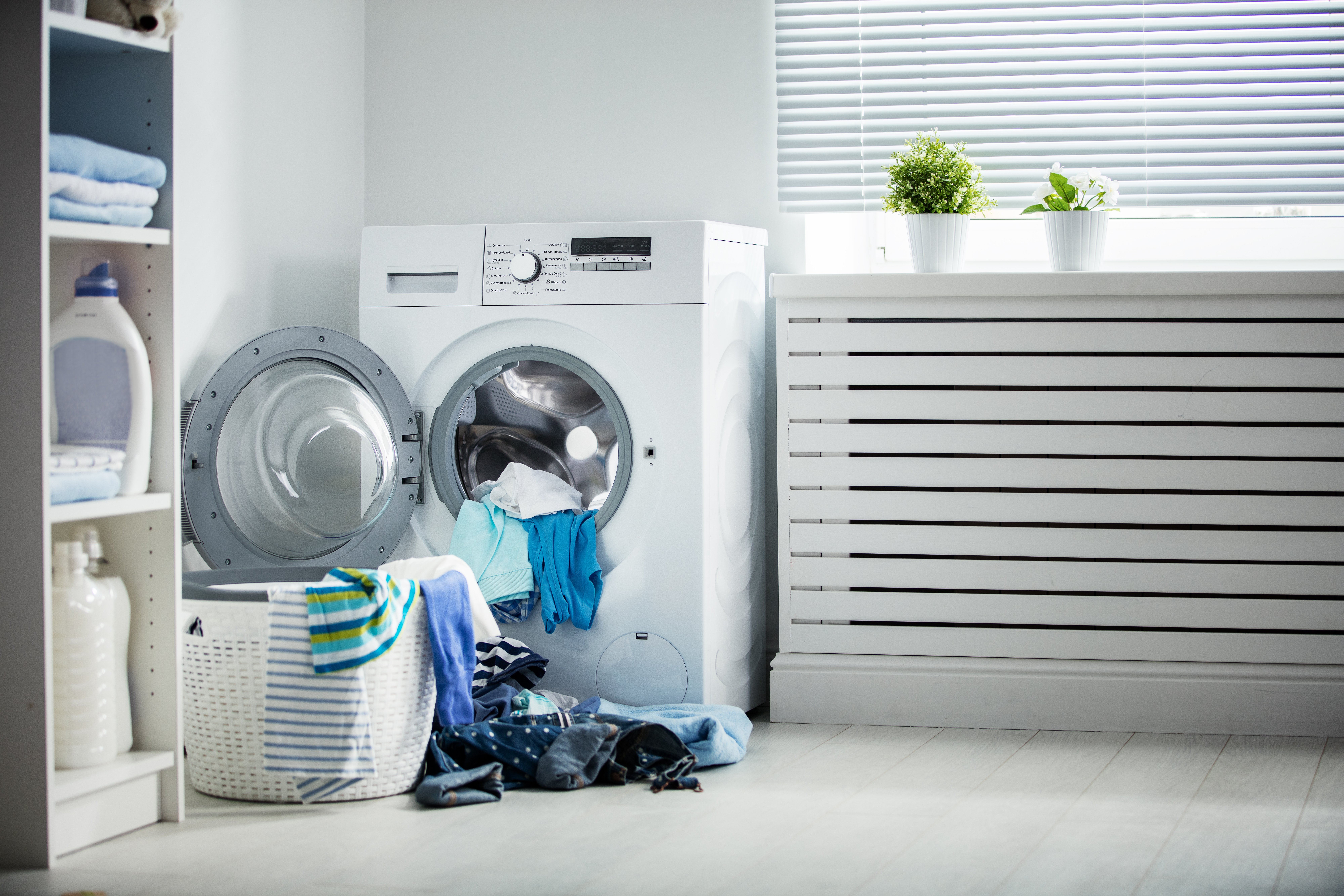 Eine Waschmaschine und ein Haufen schmutziger Kleidung zu Hause | Quelle: Shutterstock