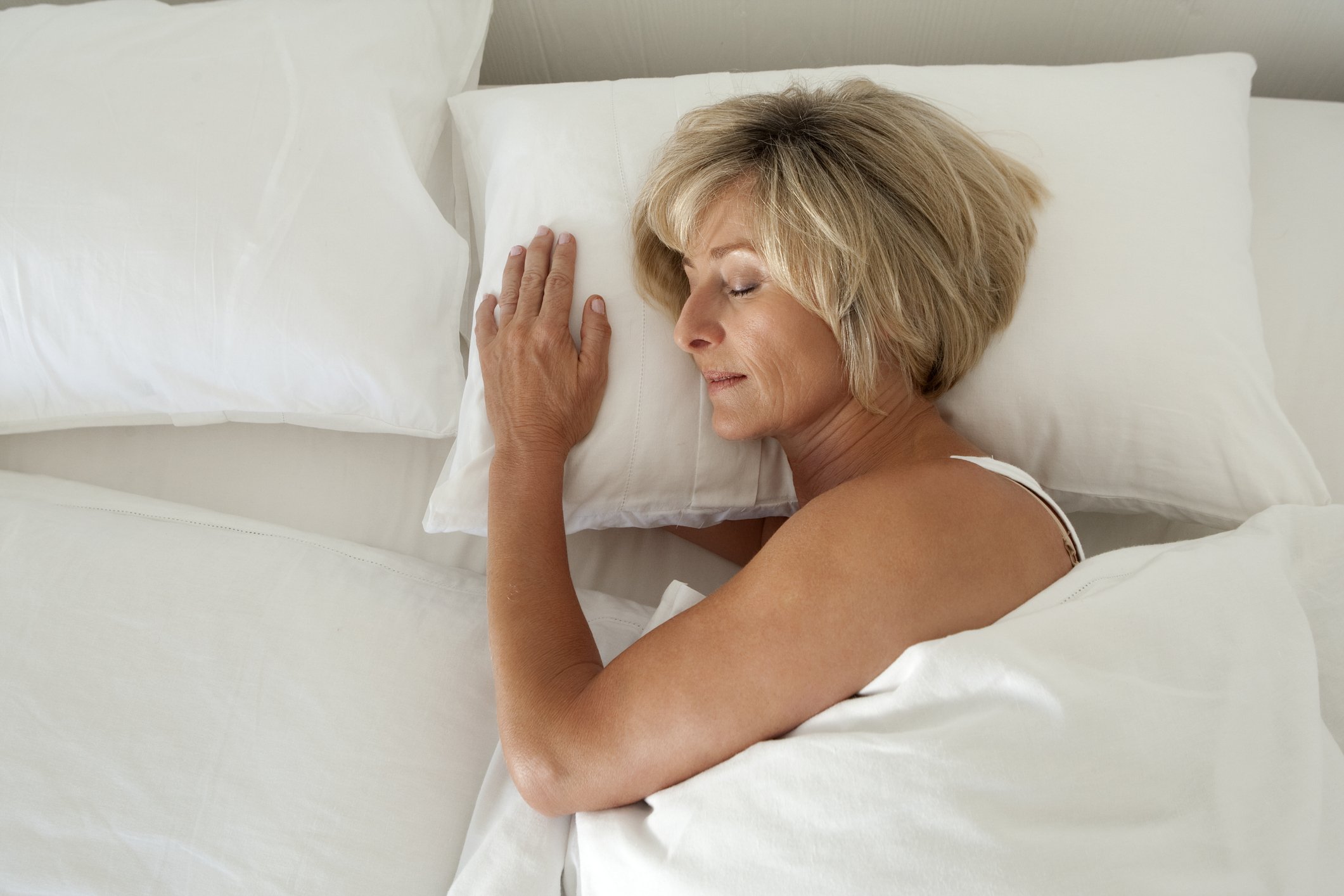 Femme mûre dormant sur le lit. | Photo : Getty Images