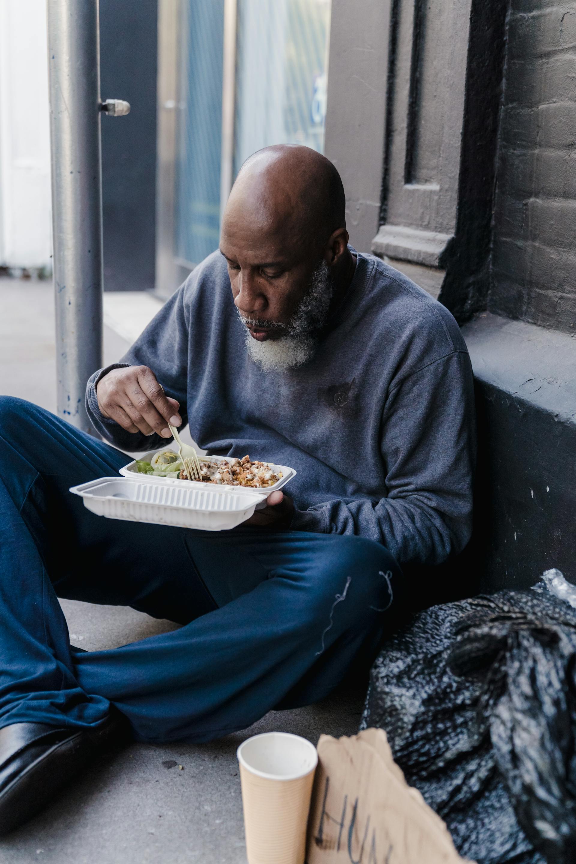 A homeless man eating his meal | Source: Pexels