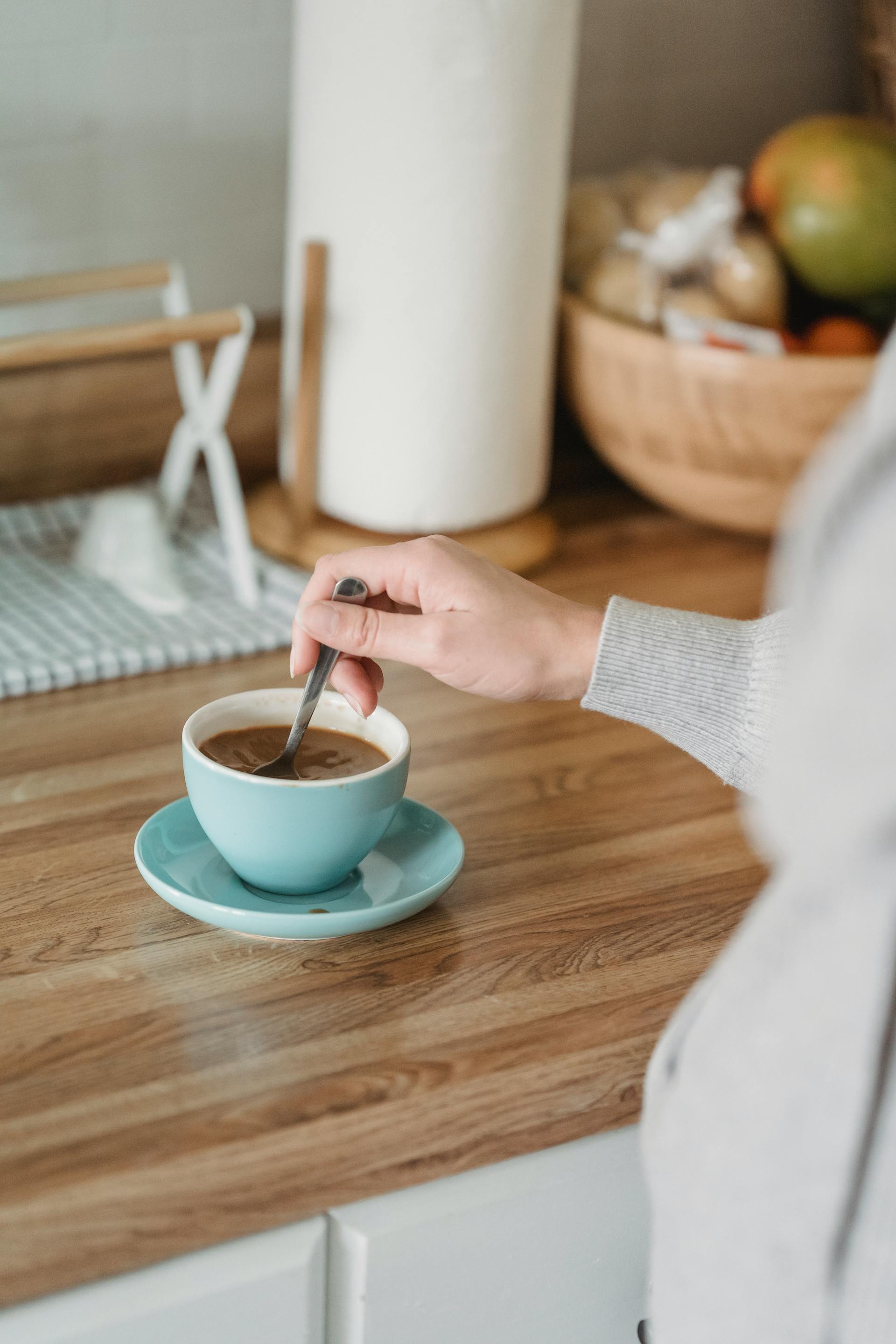 A closeup of a person stirring their coffee in the kitchen | Source: Pexels