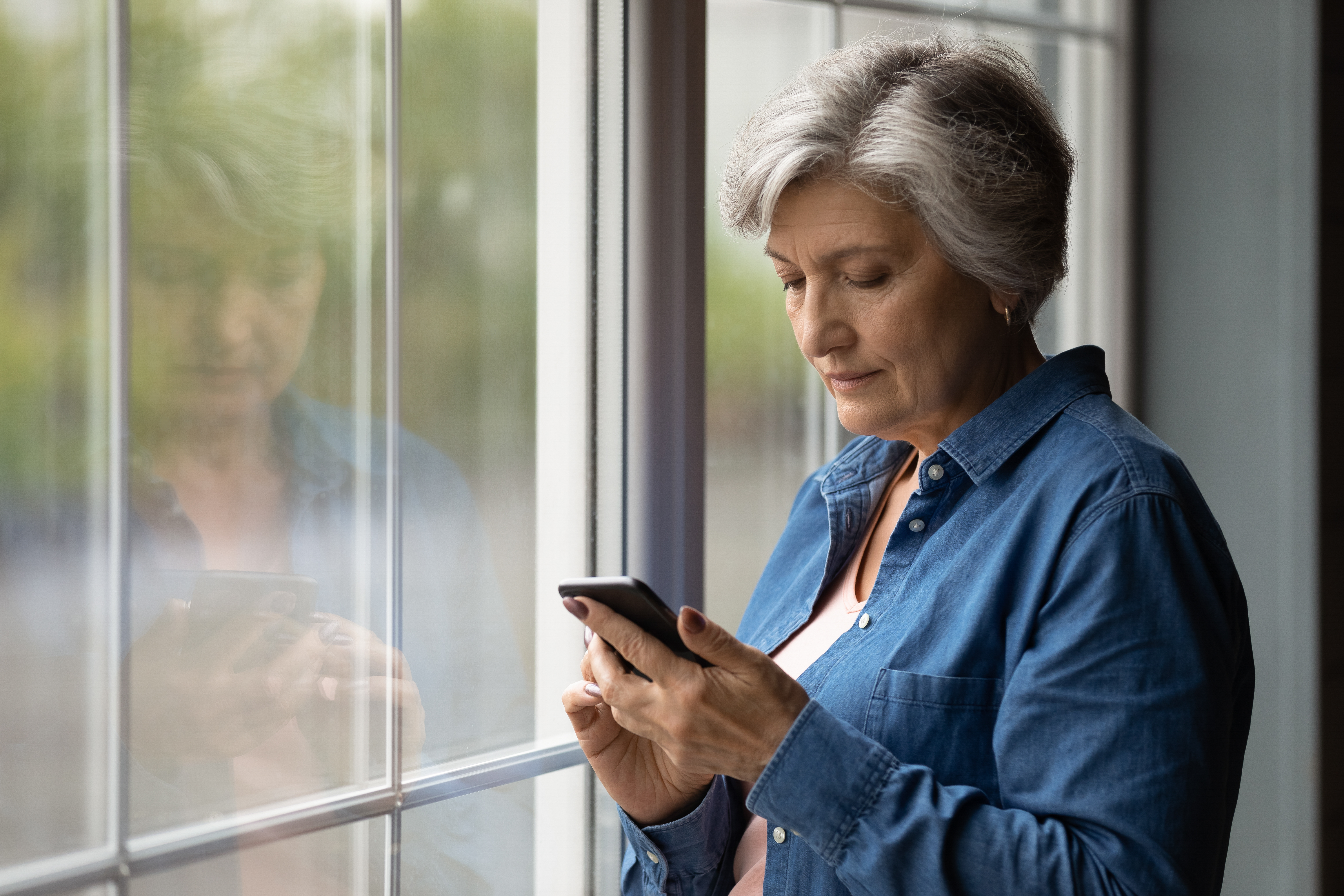 Older woman texting and looking worried. | Source: Shutterstock