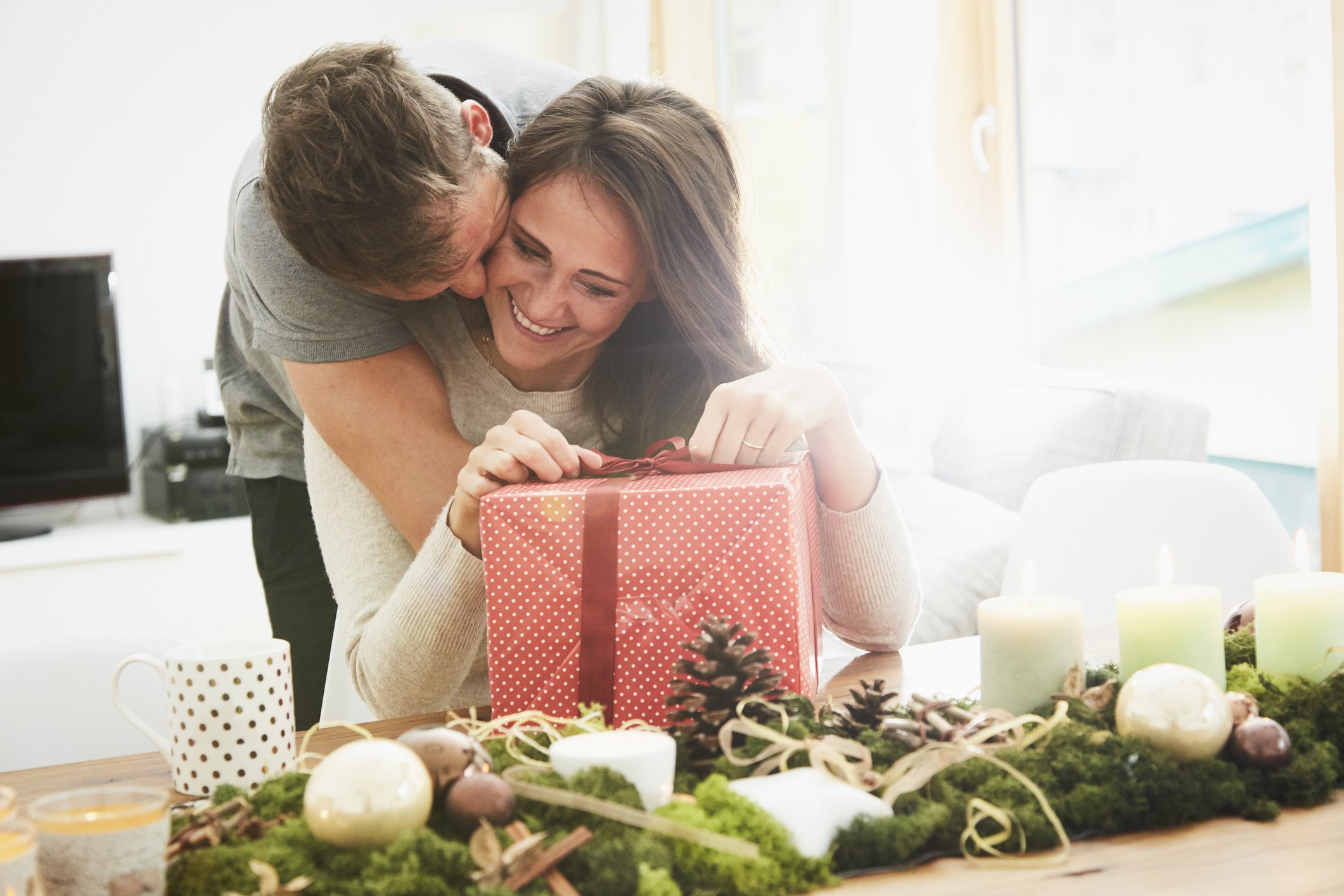 Portrait of a happy couple celebrating Christmas sitting at a decorated table | Photo: Getty Images