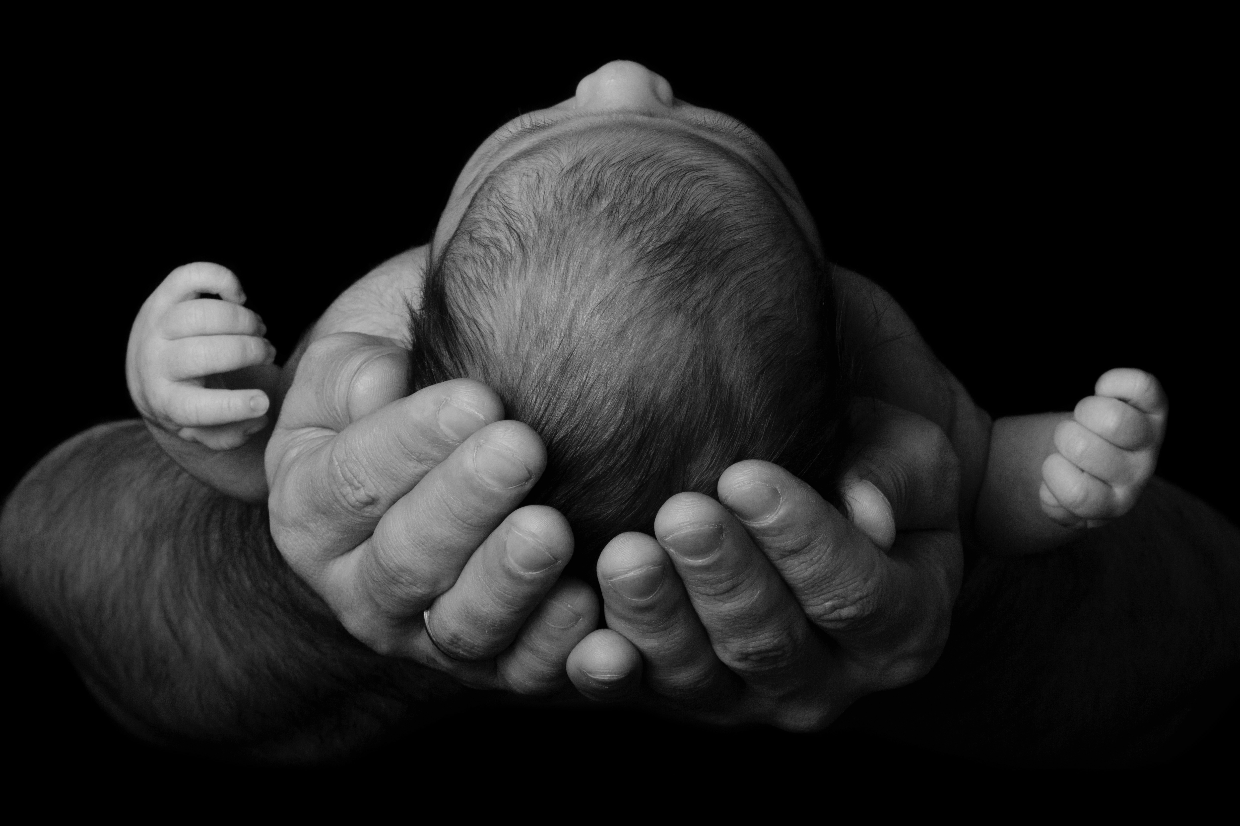 Ein Mann wiegt ein neugeborenes Baby | Quelle: Shutterstock