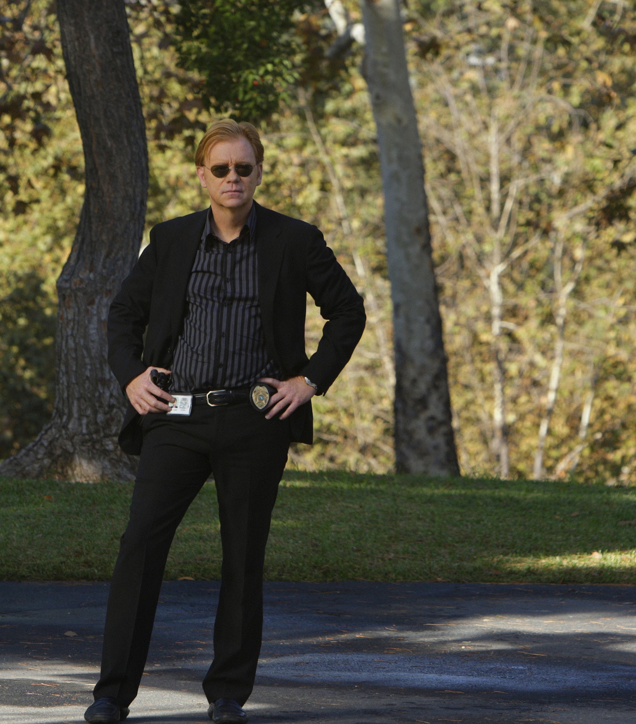 David Caruso stands outdoors in sunglasses, a black blazer, and badge as Horatio Caine in "CSI: Miami," during the episode "Head Case," which centered on a blood-covered man with memory loss.