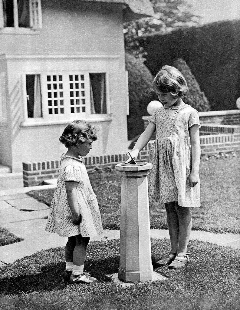 Then-Princess Elizabeth and Princess Margaret in the grounds of the model house on Elizabeth's 6th birthday, 1933. | Source: Getty Images
