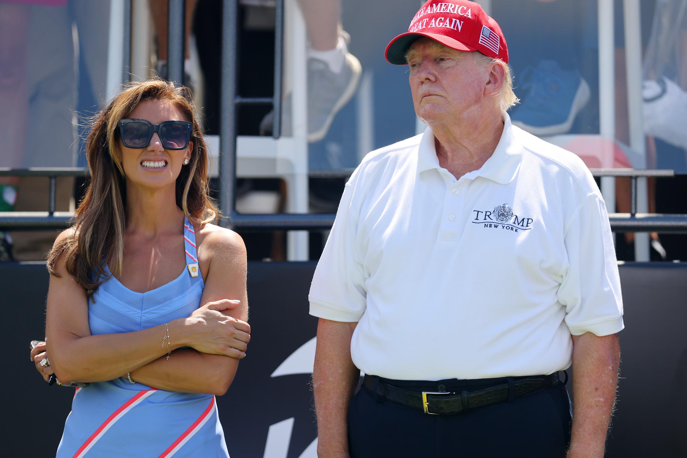 Later that same day, Donald Trump is seen at the first tee standing beside attorney Alina Habba. The sunlight makes the color difference even clearer, showing flushed skin on his face and pale arms.
