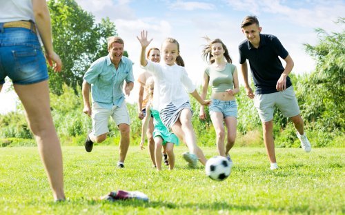 A family playing soccer in the park. | Source: Shutterstock.