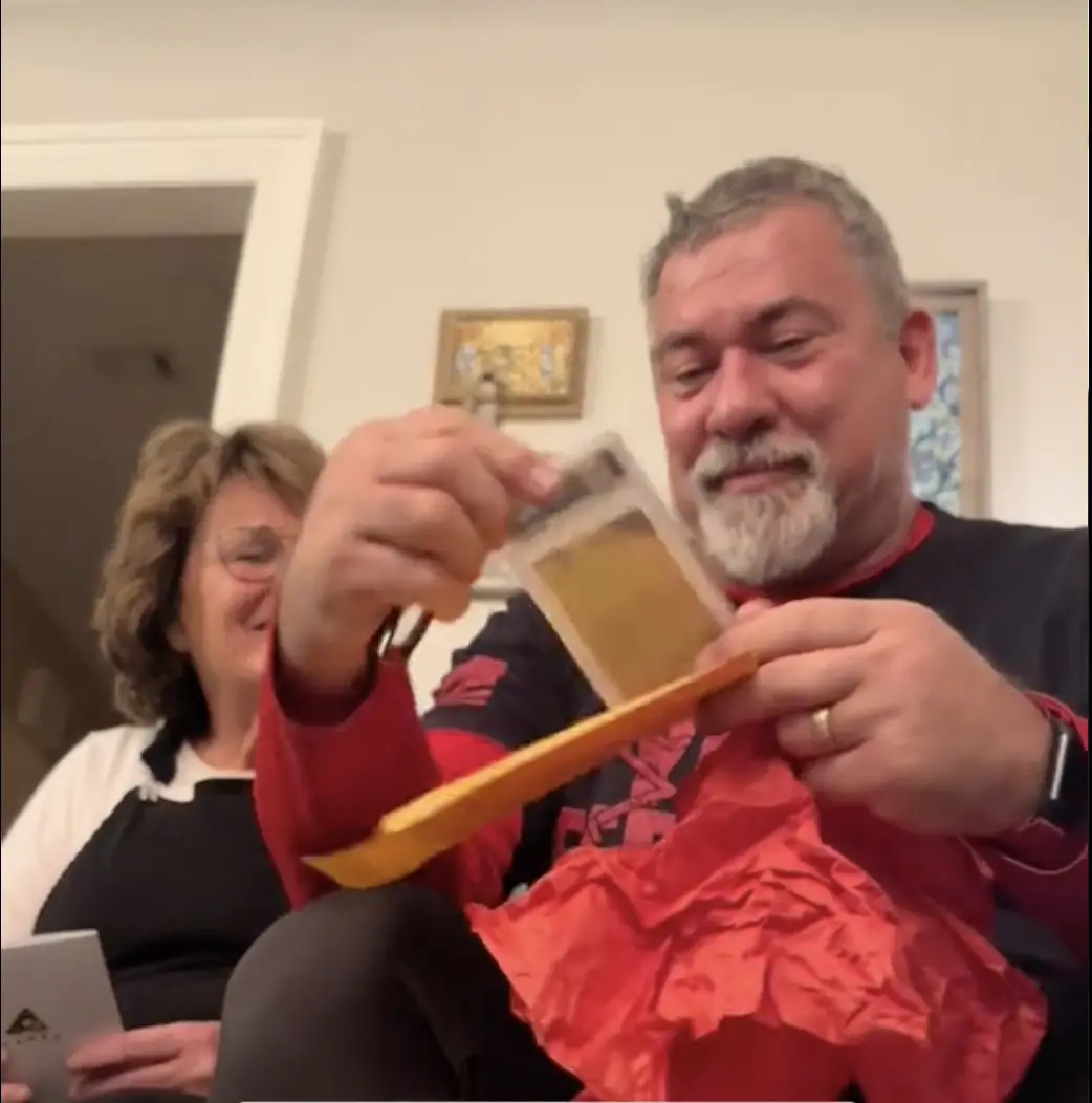 Ted Lawver unwrapping his Christmas gift | Source: TikTok/lindseyswagmom