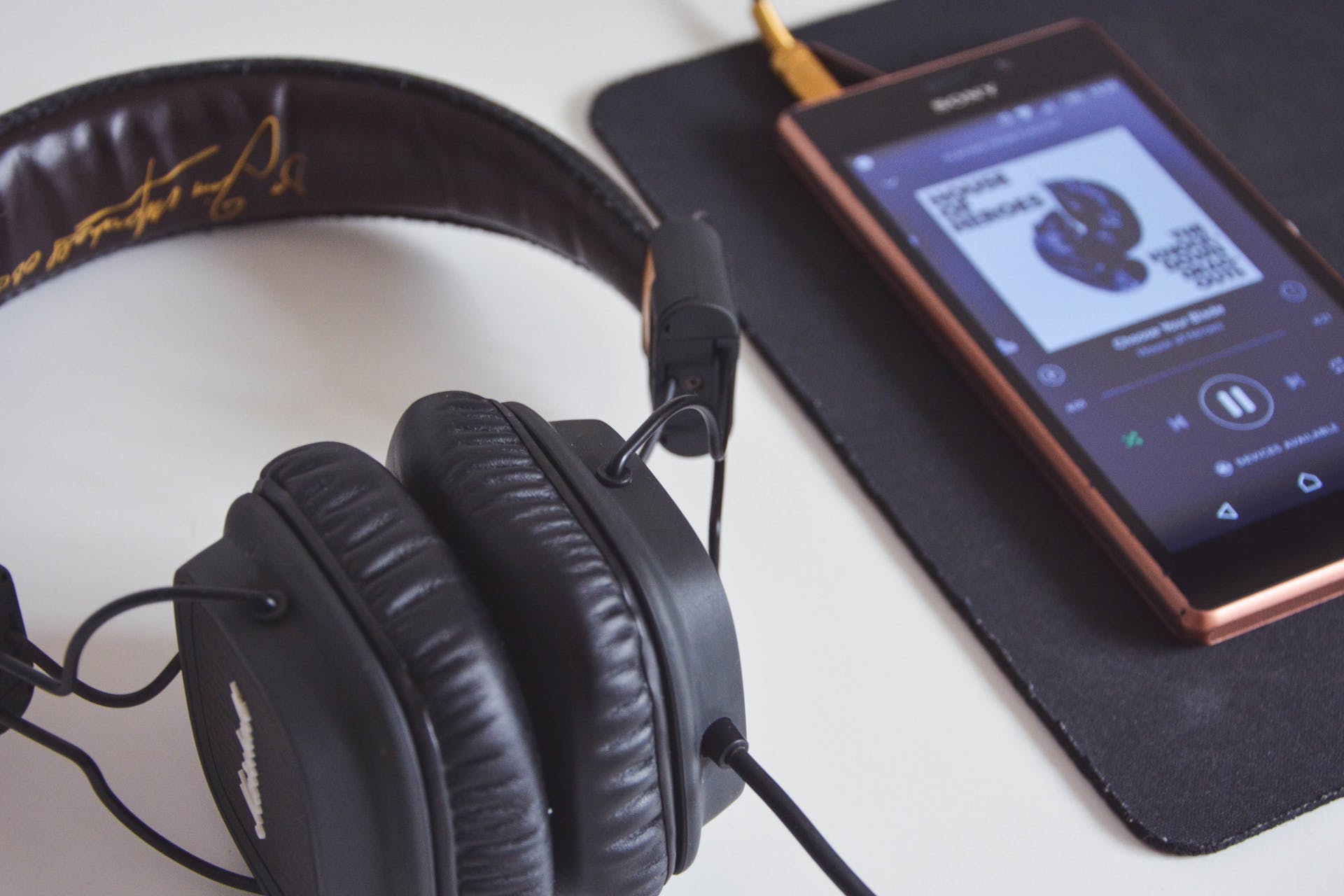 A headphone next to a phone on a table | Source: Pexels