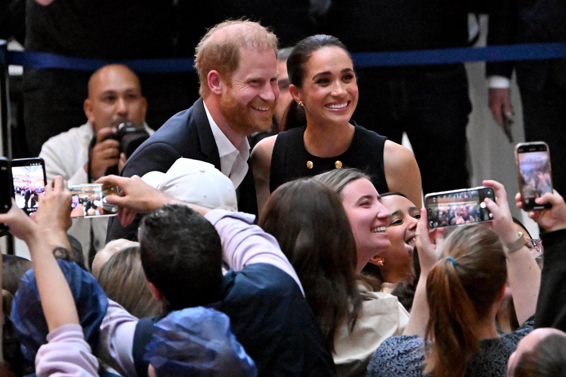 The Duke and Duchess of Sussex paused to pose for selfies with members of the public, drawing smiles and excitement from the crowd gathered at the hospital on 14 April 2026. | Source: Getty Images