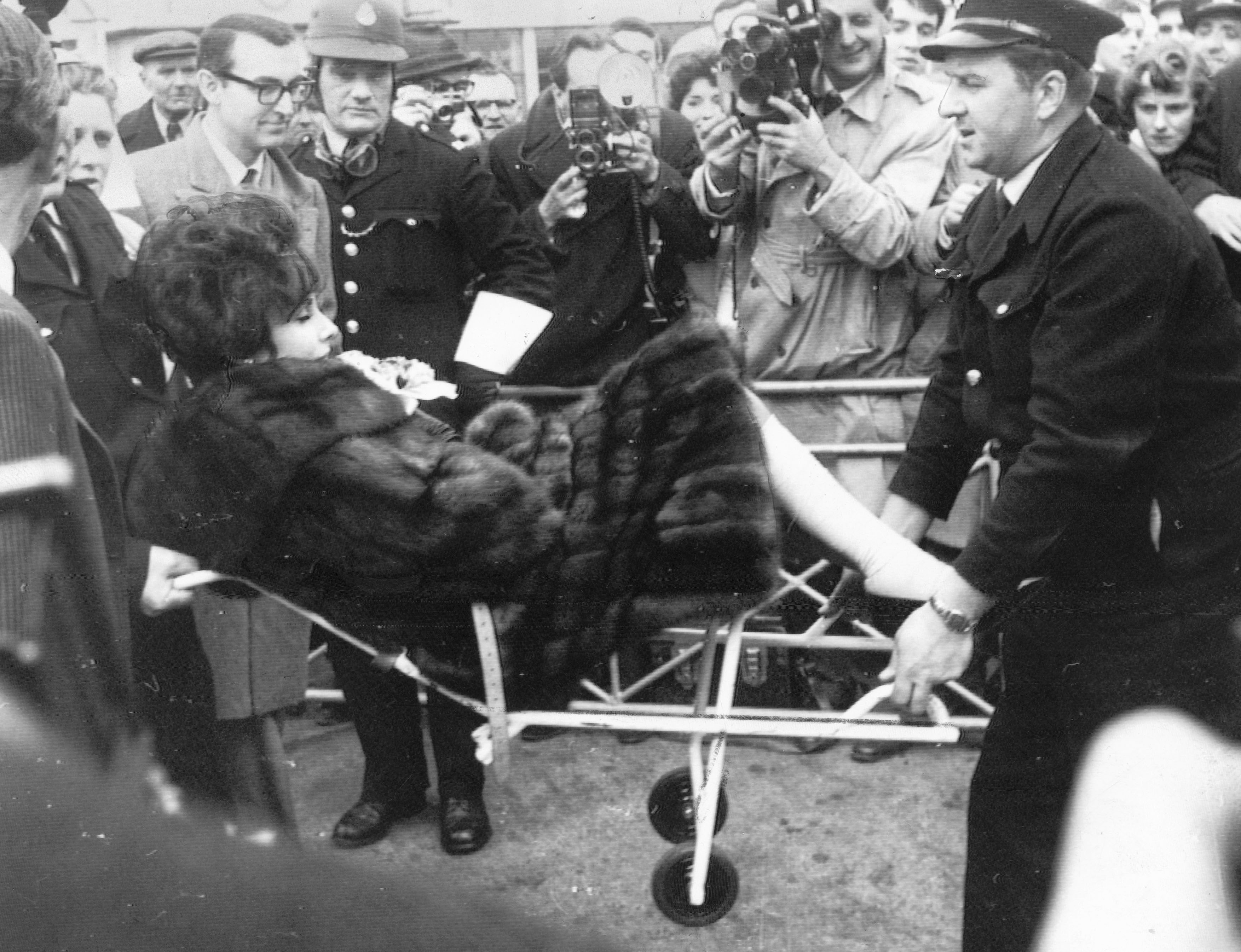 Elizabeth Taylor fotografiada saliendo de una clínica londinense en un carrito el 26 de marzo de 1961 | Foto: Getty Images