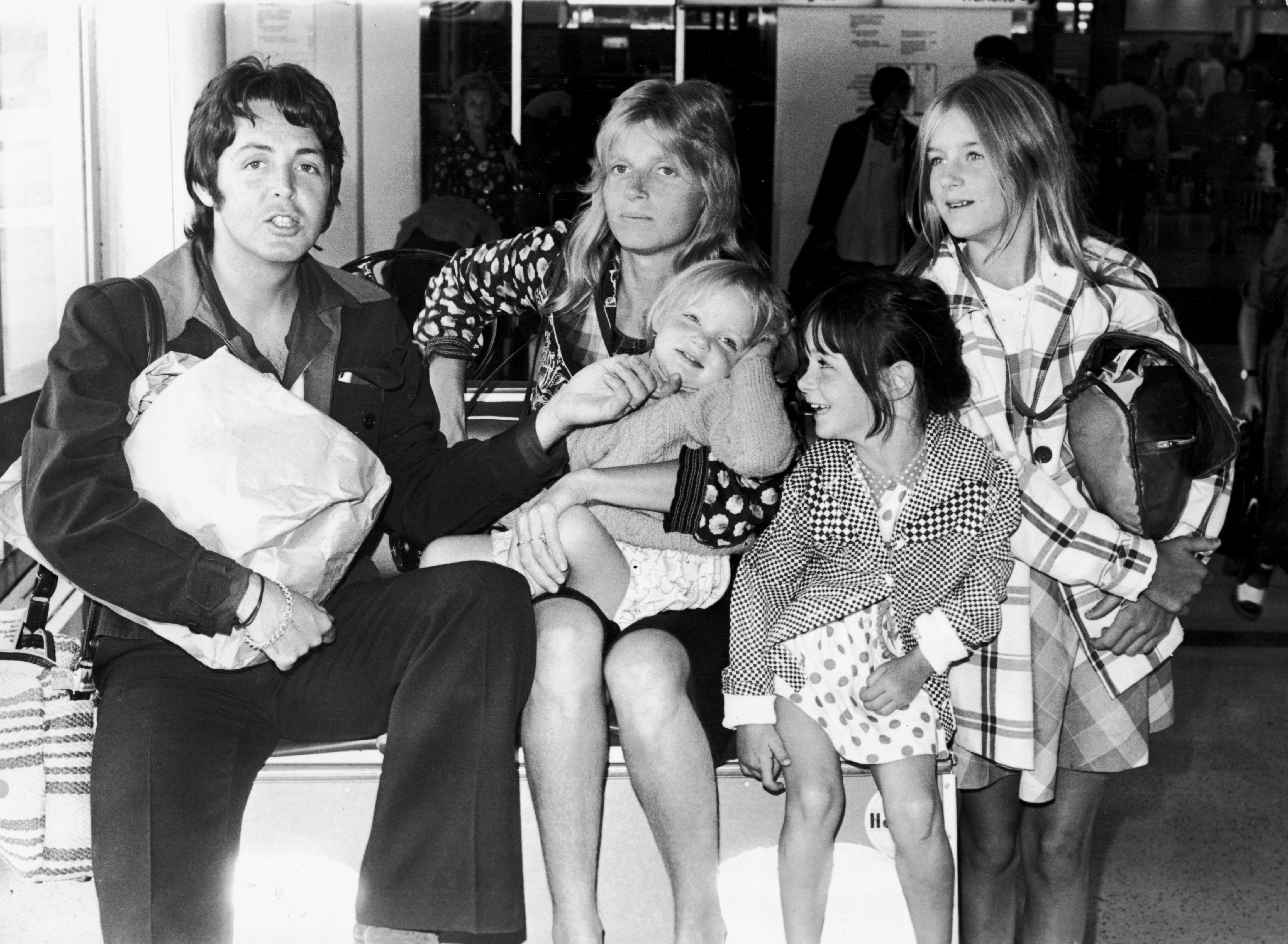 Paul McCartney poses with his wife Linda McCartney, and their daughters, Stella, Mary, and Heather, on August 2, 1974, in Heathrow Airport in London, England. | Source: Getty Images