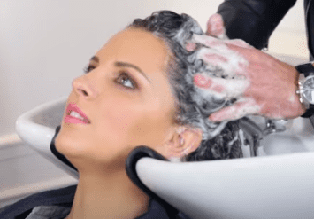 Aufnahme einer Frau beim Haarewaschen | Quelle: YouTube/Elle Coiffure