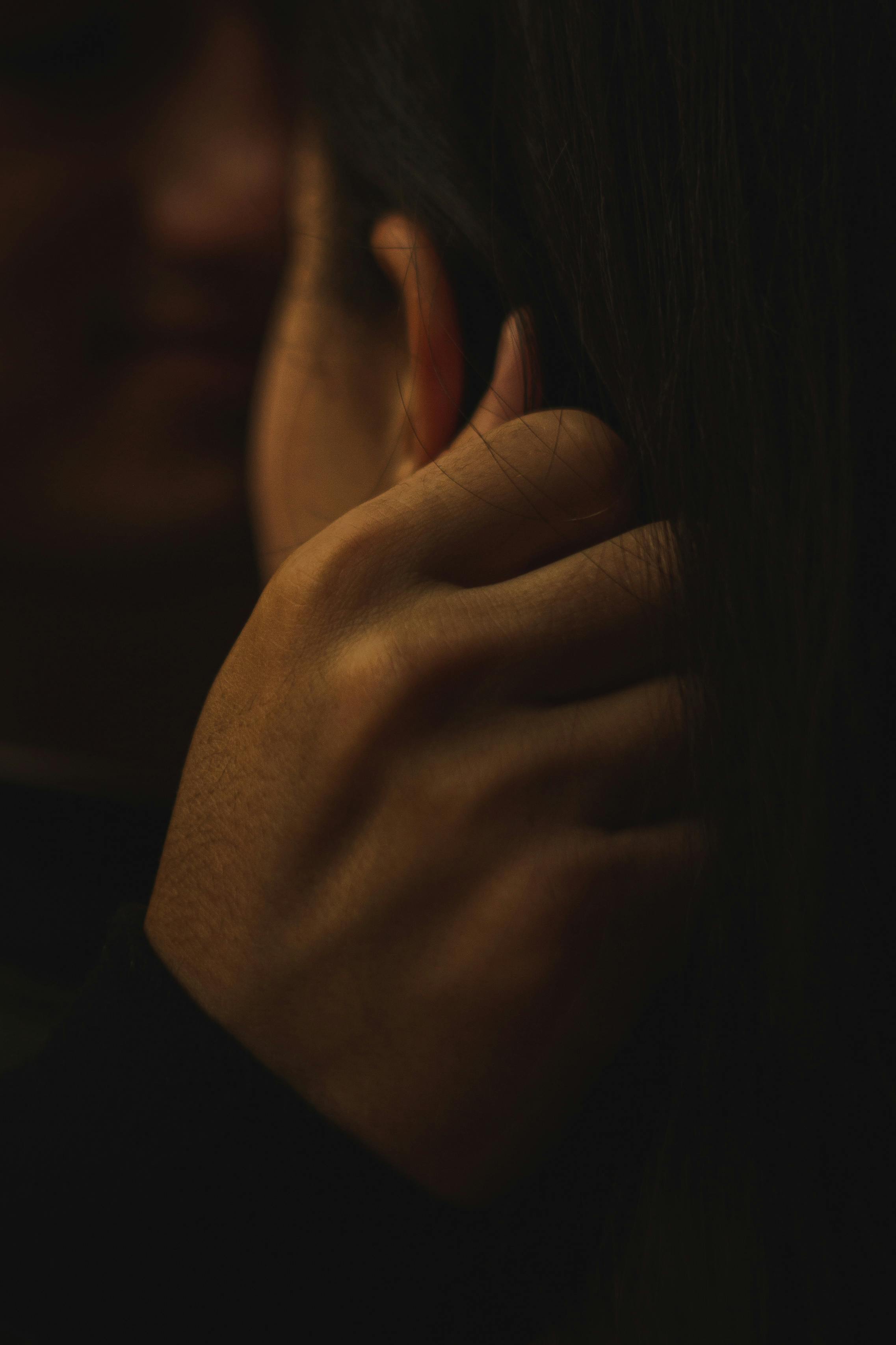 A man touching a woman's ear | Source: Pexels