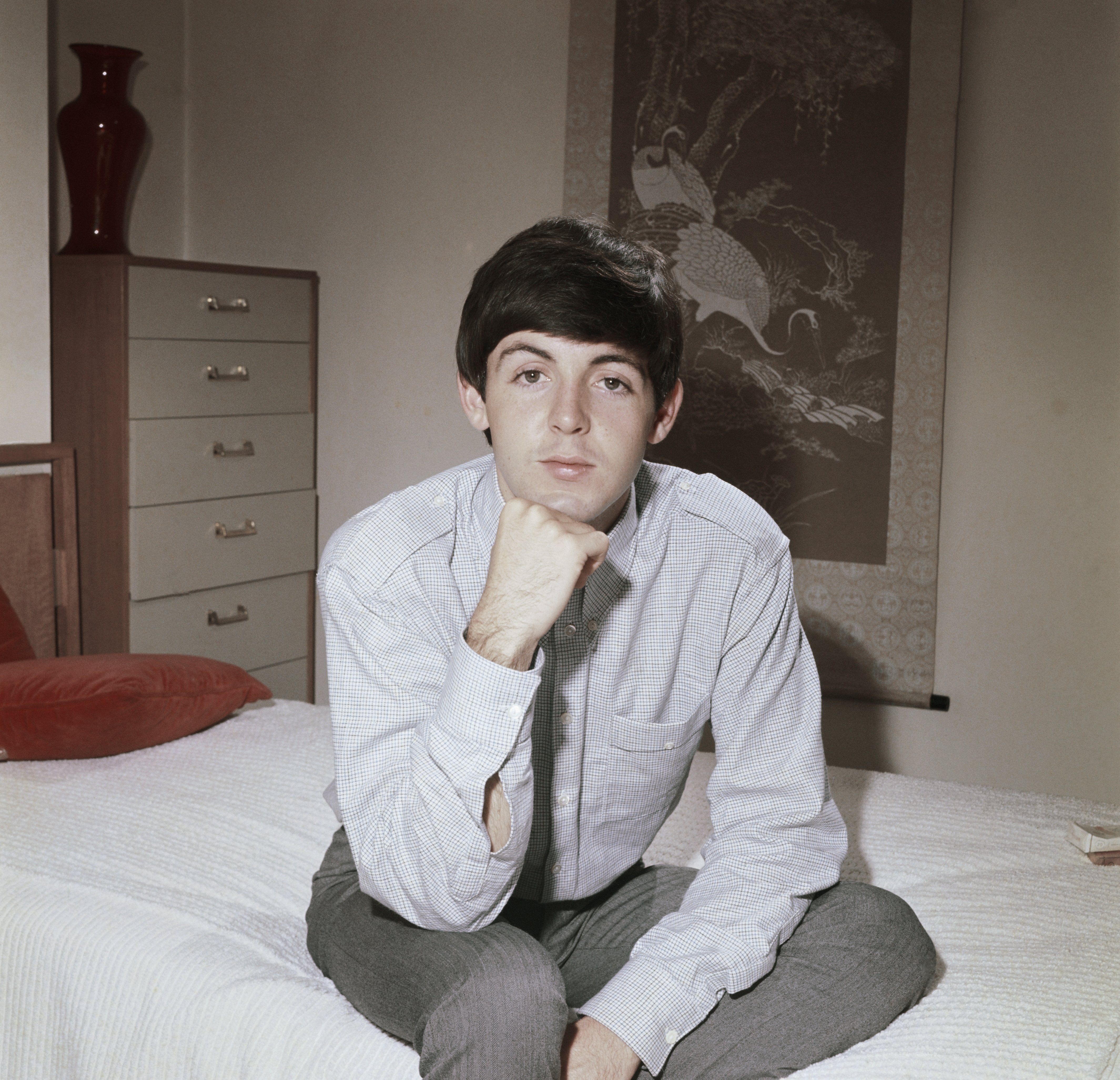 Bassist Paul McCartney of the rock band "The Beatles" poses for a portrait sitting on a bed in circa 1964 in London, England circa 1964 | Source: Getty Images 