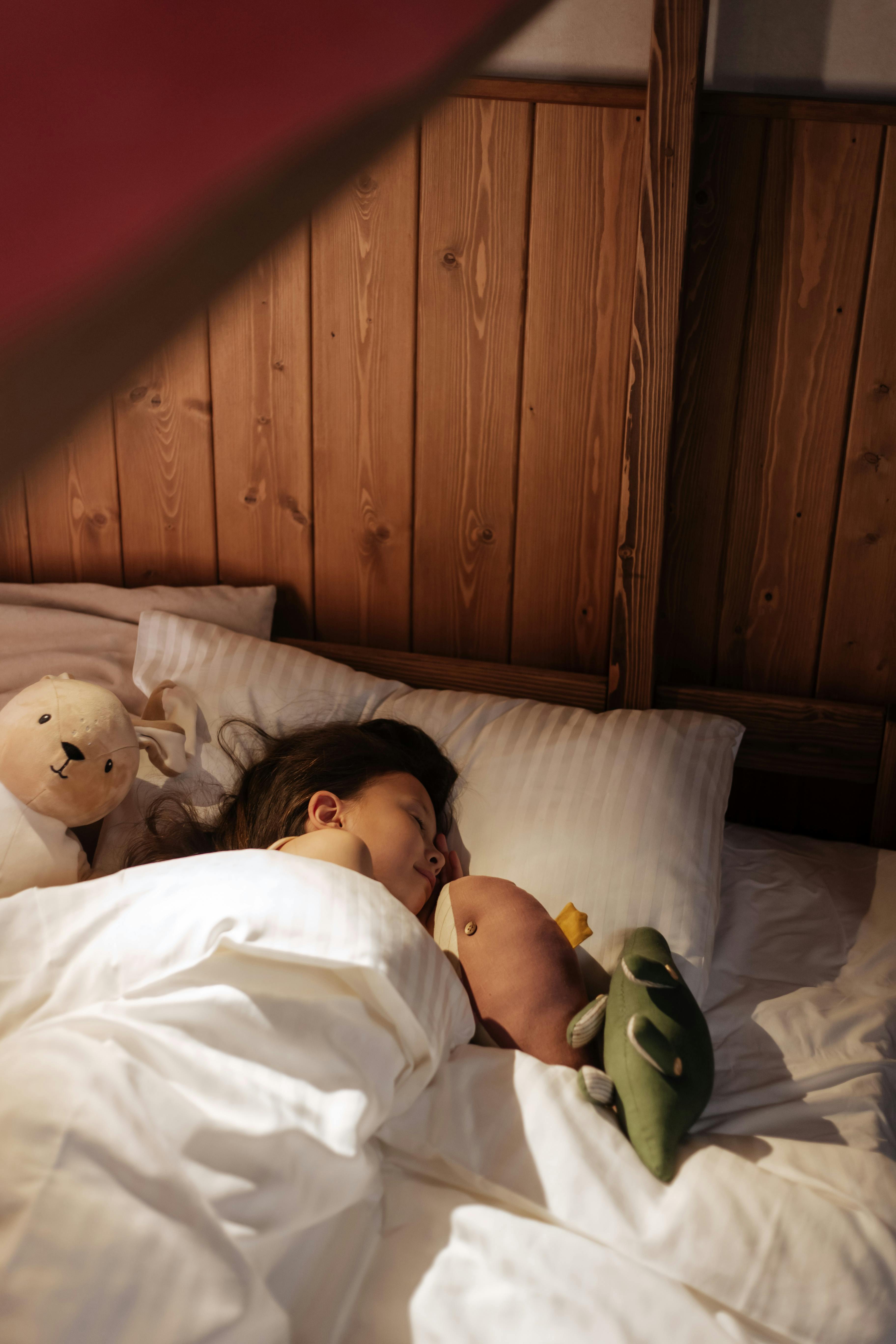 A little girl sleeping with her stuffed toys | Source: Pexels