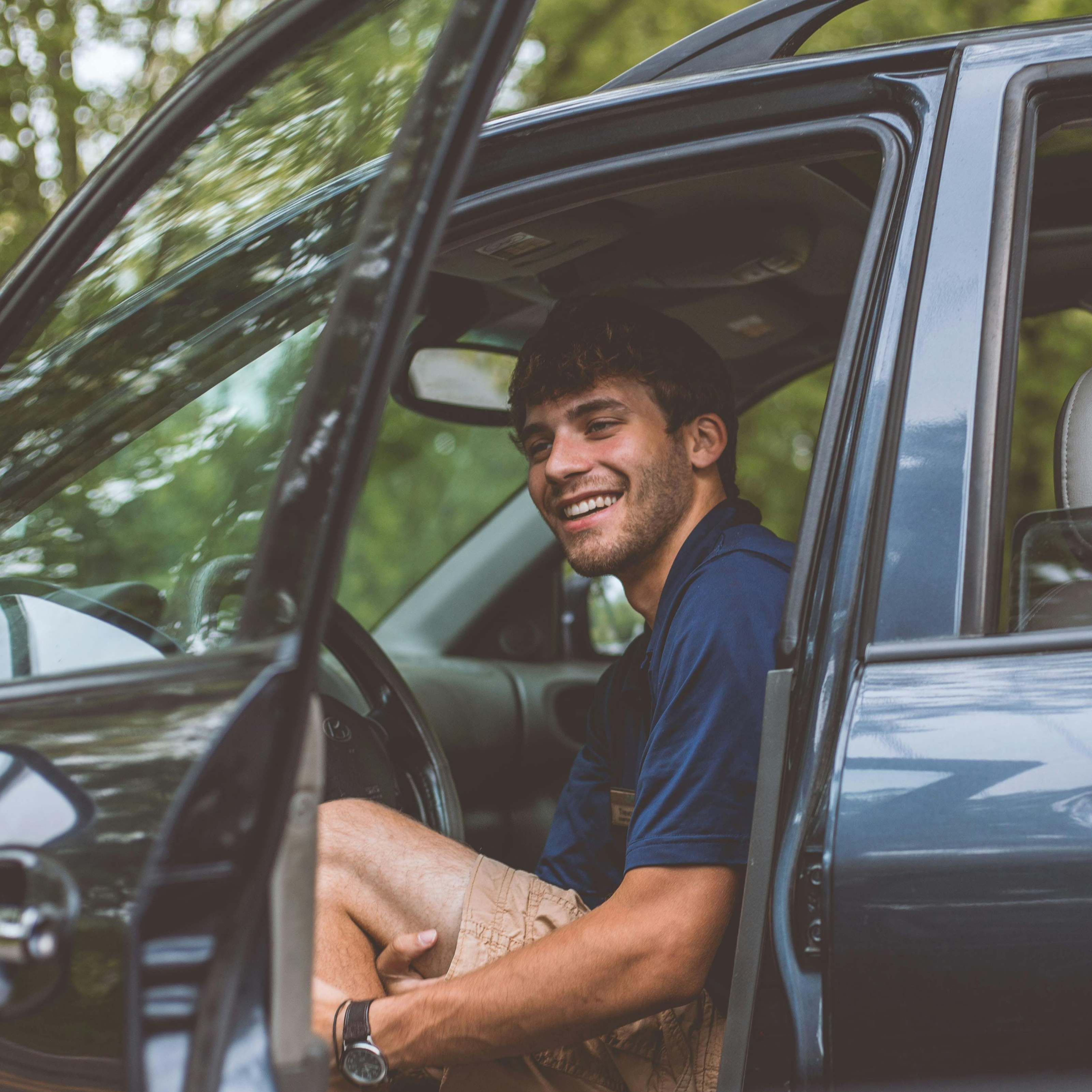 A man opening the driver's side door of a car, smiling | Source: Pexels