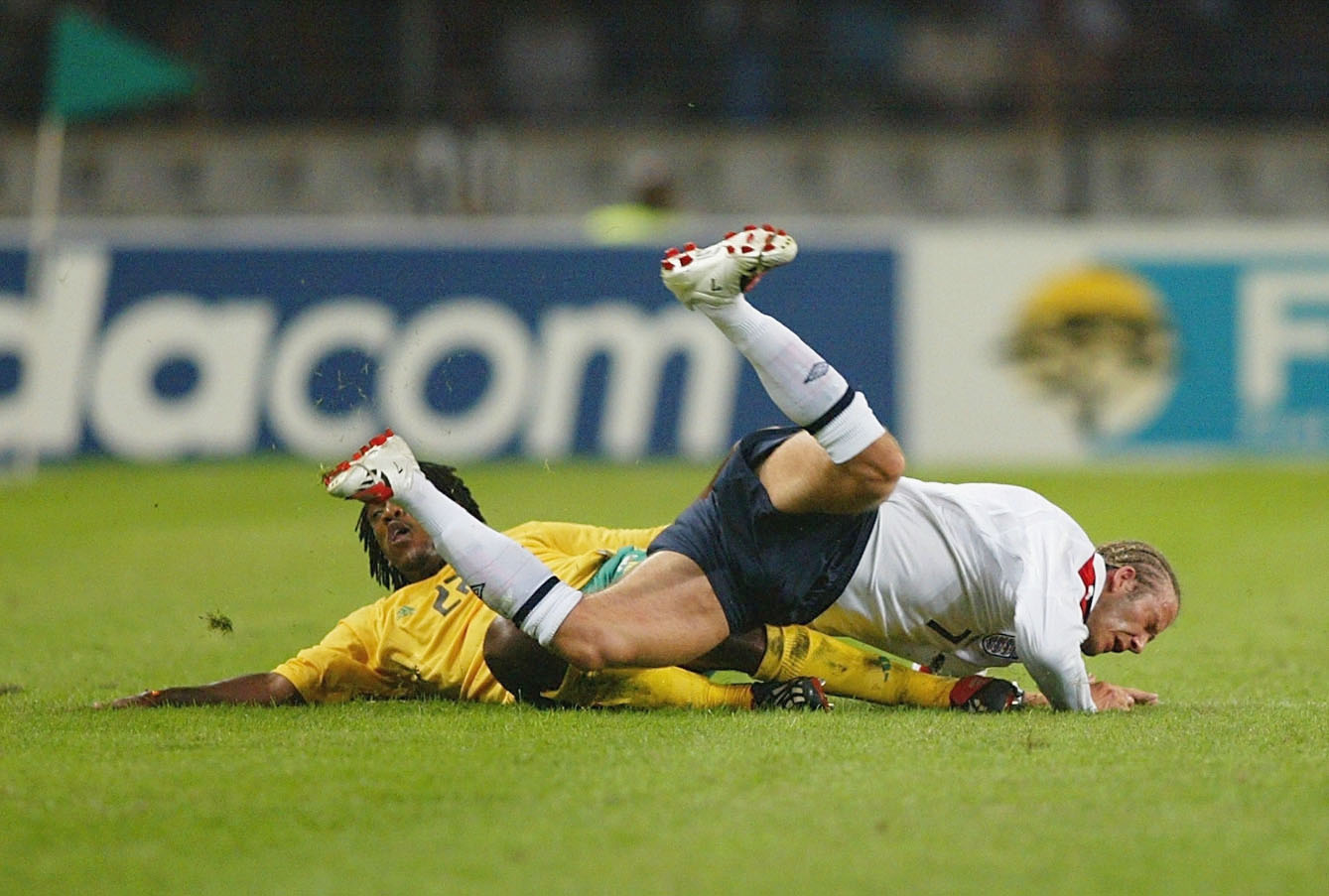 David Beckham tackled by Thabang Molefe during a match between South Africa and England on May 22, 2003 in Durban, South Africa | Source: Getty Images