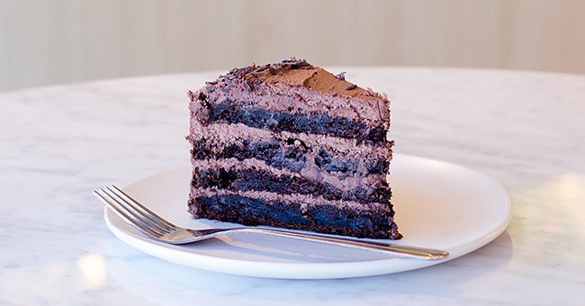A small piece of a larger portion of a freshly baked chocolate cake | Photo: unsplash.com/Will Echols