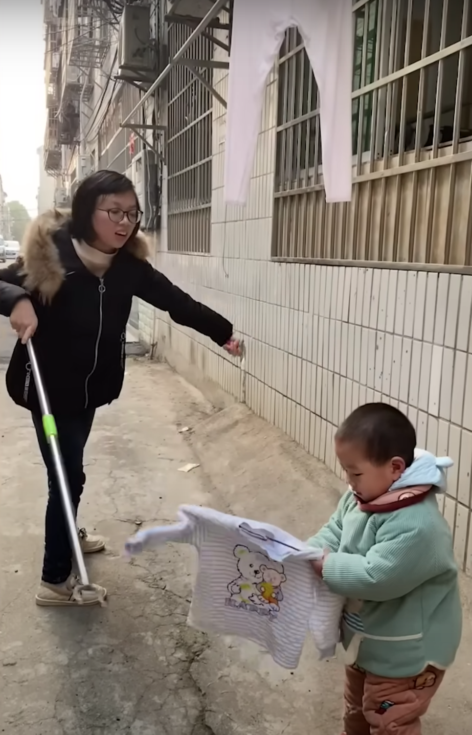 Pomelo ayuda a su madre a lavar ropa. | Foto: Youtube.com/South China Morning Post