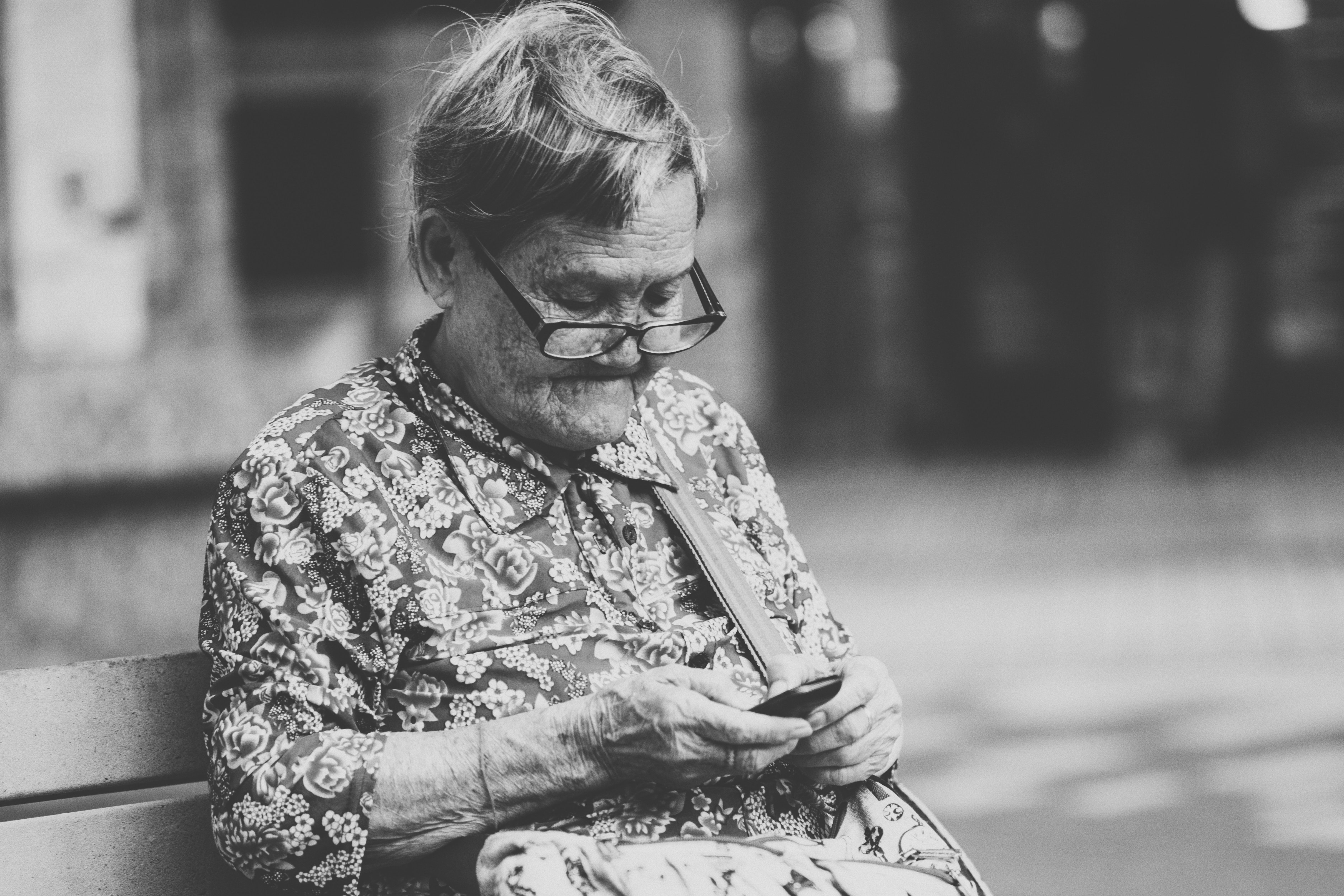 Une Grand-mère assise sur le banc qui utilise un téléphone  | Source : Unsplash