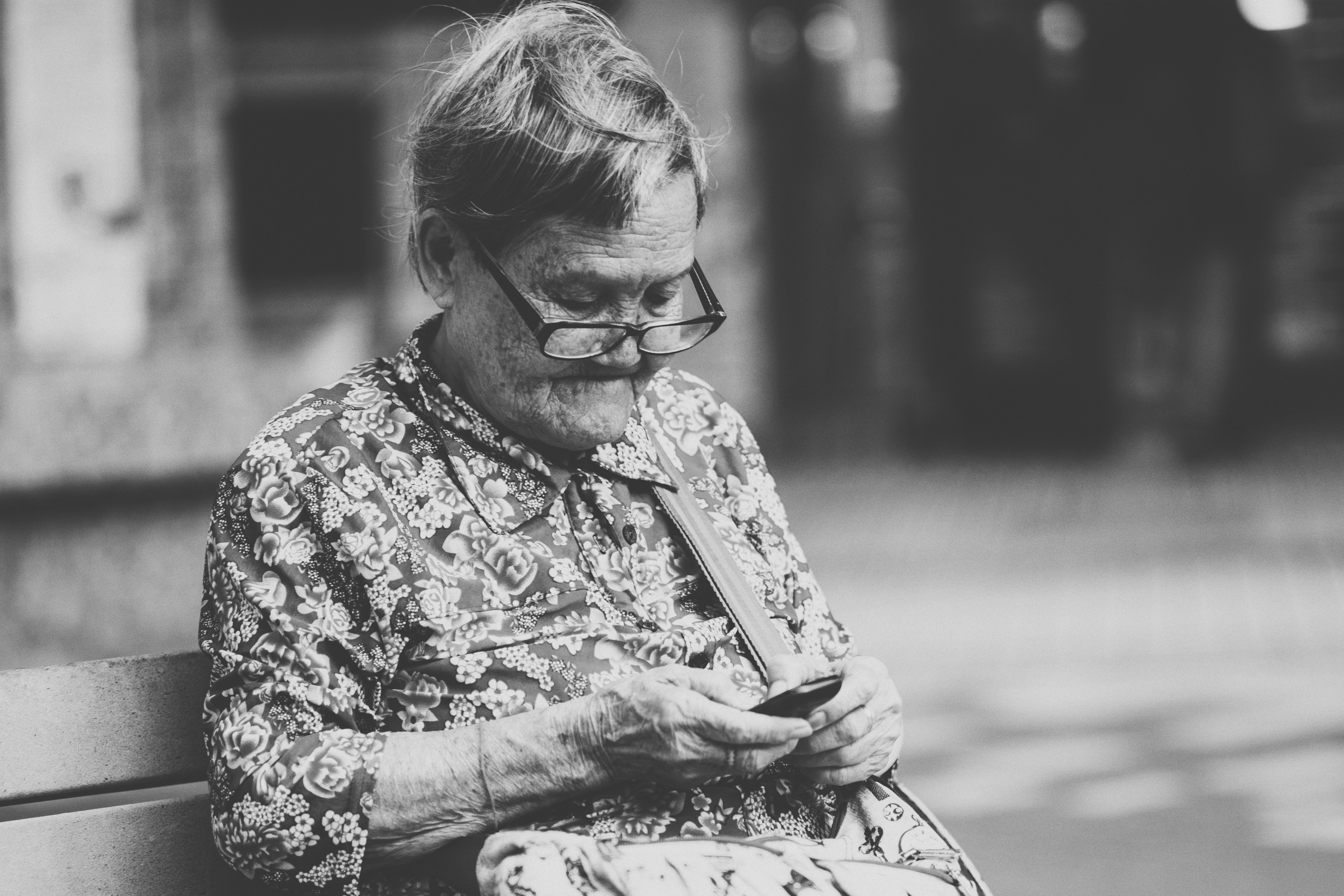 Une Grand-mère assise sur le banc qui utilise un téléphone | Source : Unsplash
