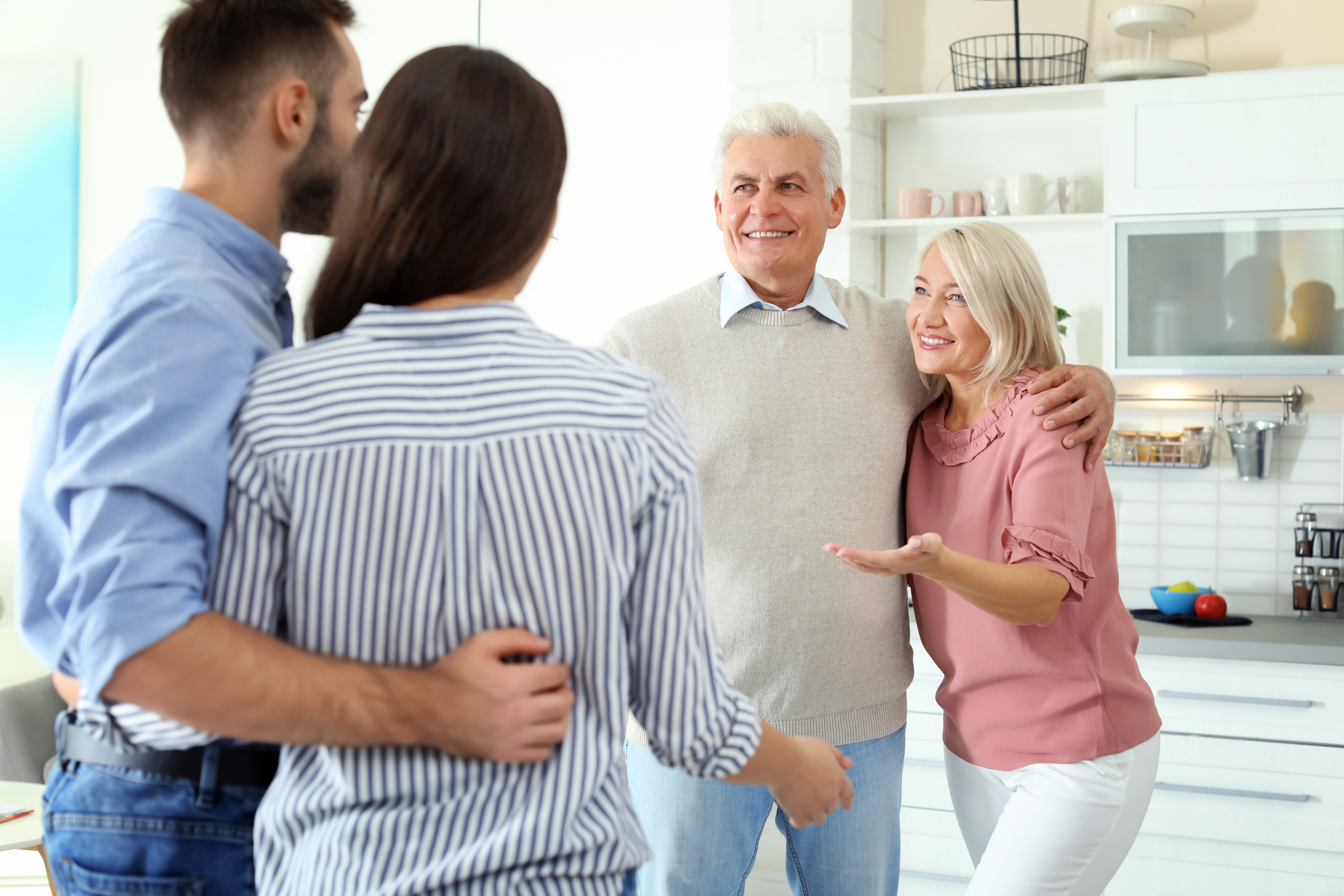 An elderly couple standing in front of a younger couple | Source: Shutterstock