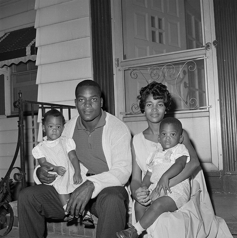 Jim Brown, fullback of the Cleveland Browns, sits in front of his home with wife, Sue and twins Kim and Kevin, 19-months-old. I Image: Getty Images.