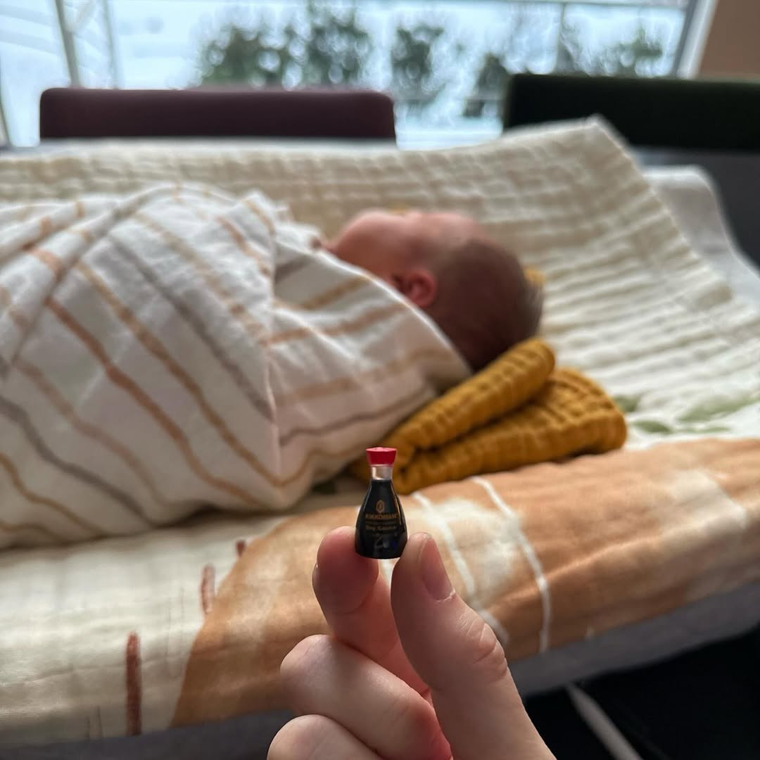 Scottie Rose Hewitt Davidson sleeps peacefully beside a tiny soy sauce bottle, playfully held for scale, as posted on December 18, 2025 | Source: Instagram/elsie