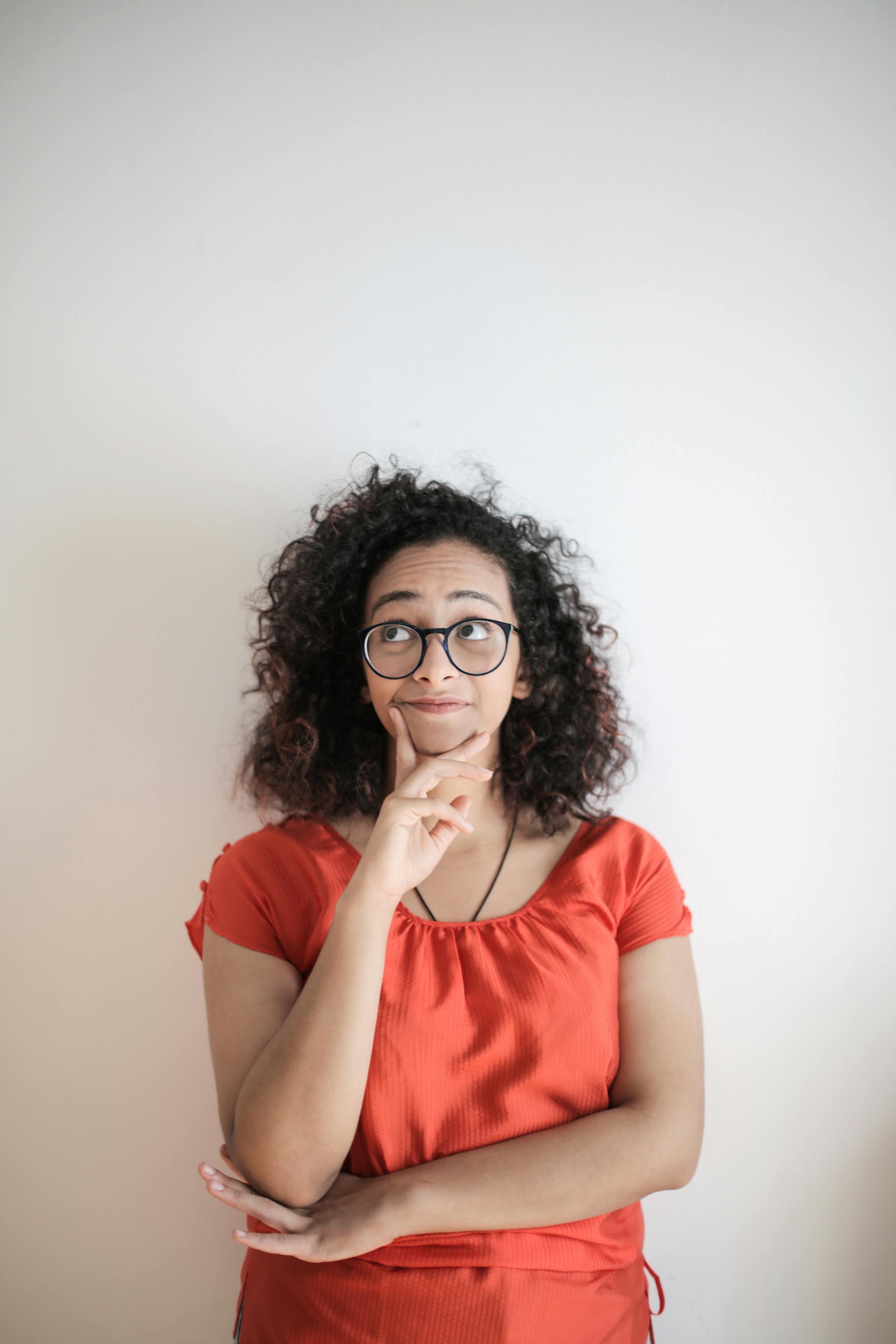 A woman standing against a wall, thinking | Source: Pexels