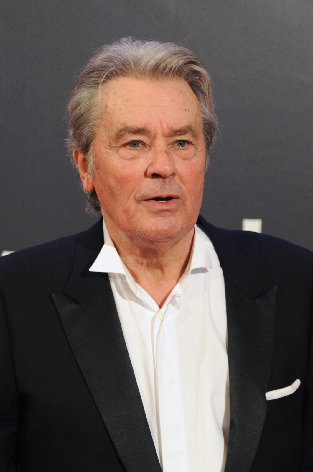 Alain Delon avec une veste noire et chemise blanche. | Photo : GettyImage