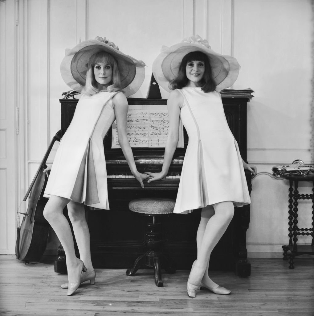 13 juin 1966 : Catherine Deneuve, actrice de cinéma, et sa sœur aînée Françoise Dorleac (1942-1967) posent contre un piano sur le tournage du film Les Demoiselles de Rochefort en France | Source : Getty Images.