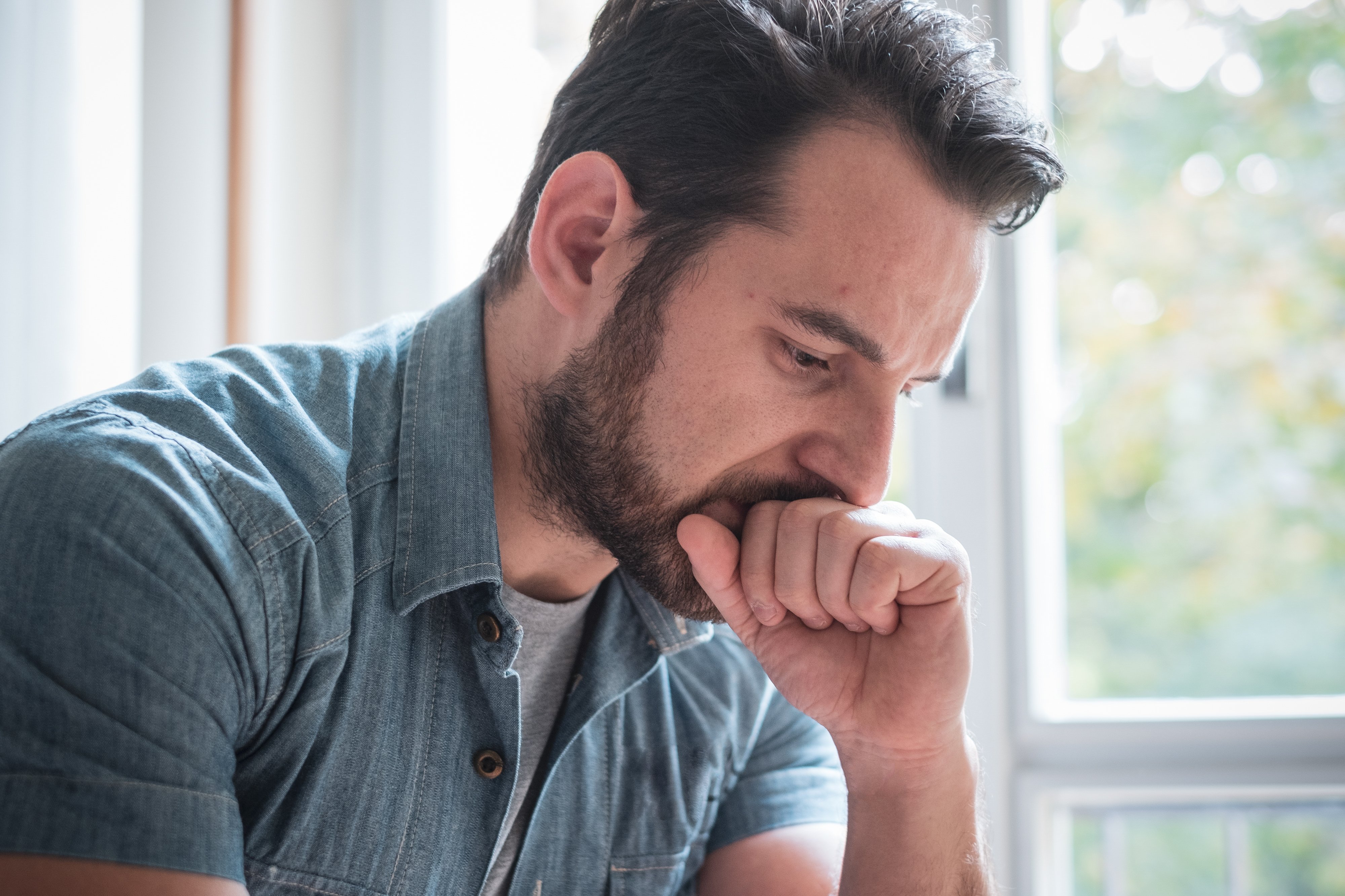 A man sitting alone in a room and lost in thoughts | Photo: Shutterstock.com
