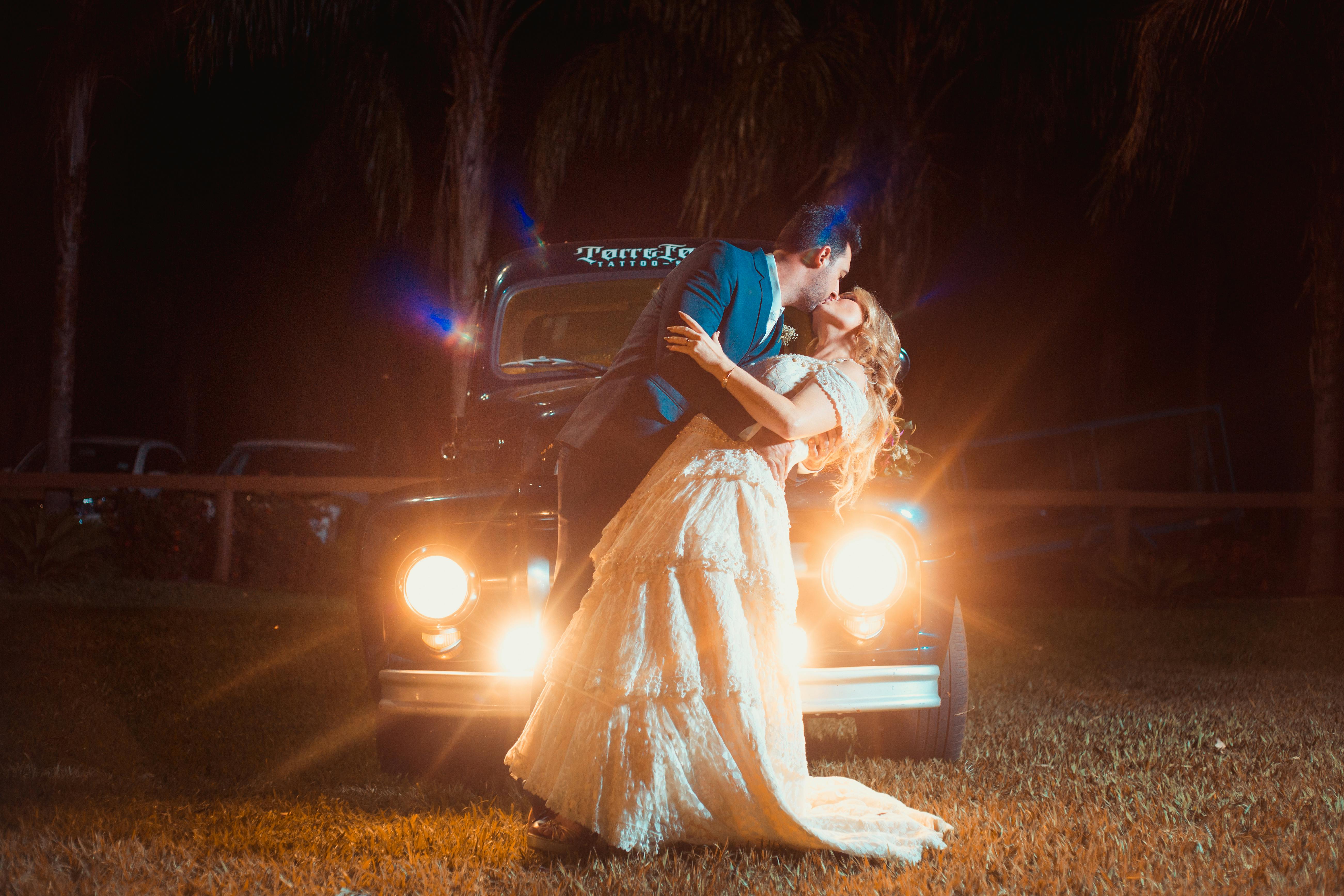 A man and woman kissing passionately in front of a car | Source: Pexels