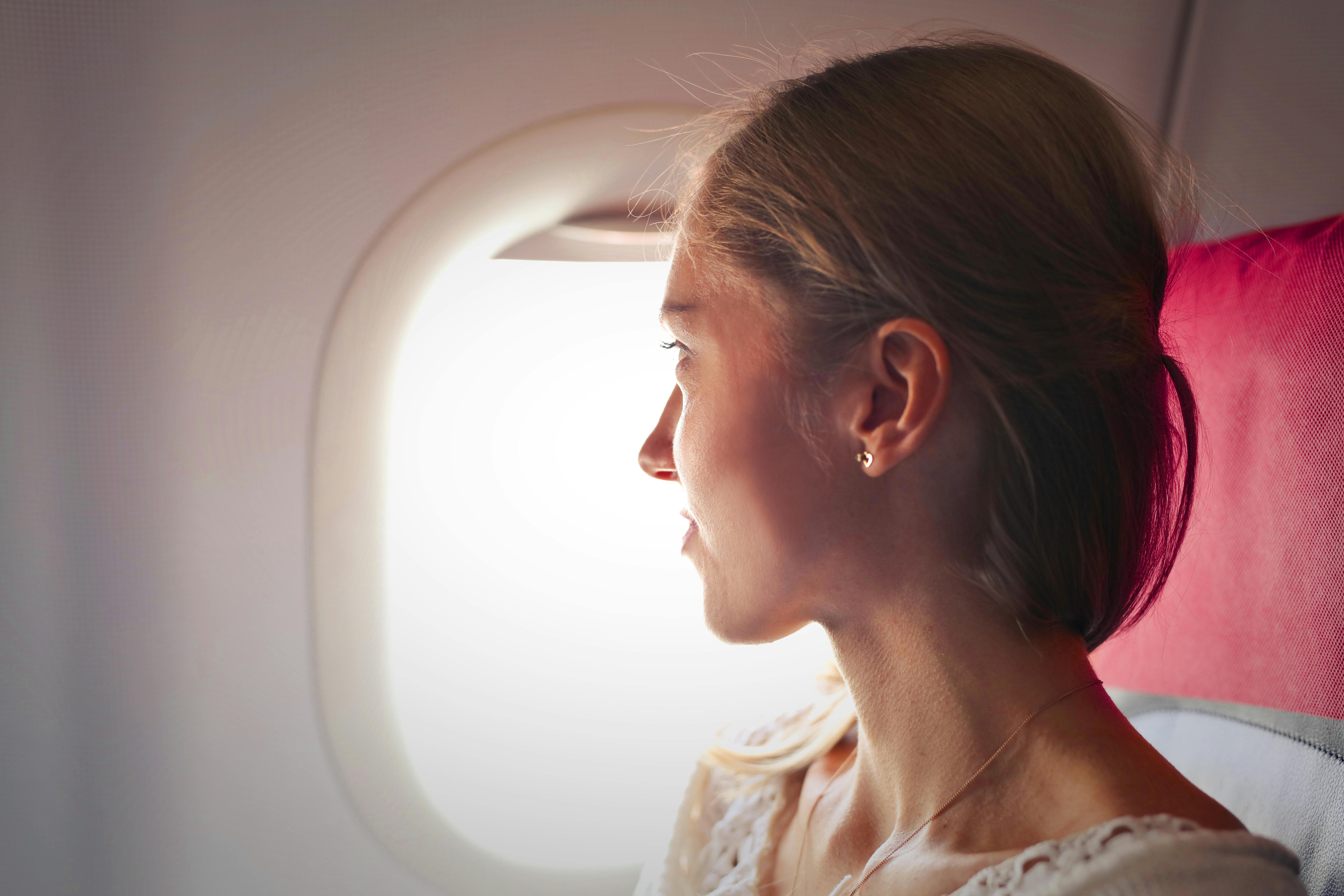 A woman in an airplane window seat | Source: Pexels