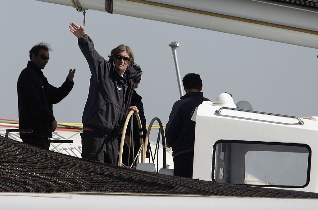 Le skipper français Olivier De Kersauson salue depuis son bateau "Geronimo" avant le départ de l'Oryx Quest 2005 Round-the-globe yachting race à Doha, le 5 février 2005 au Qatar. | Photo : Getty Images