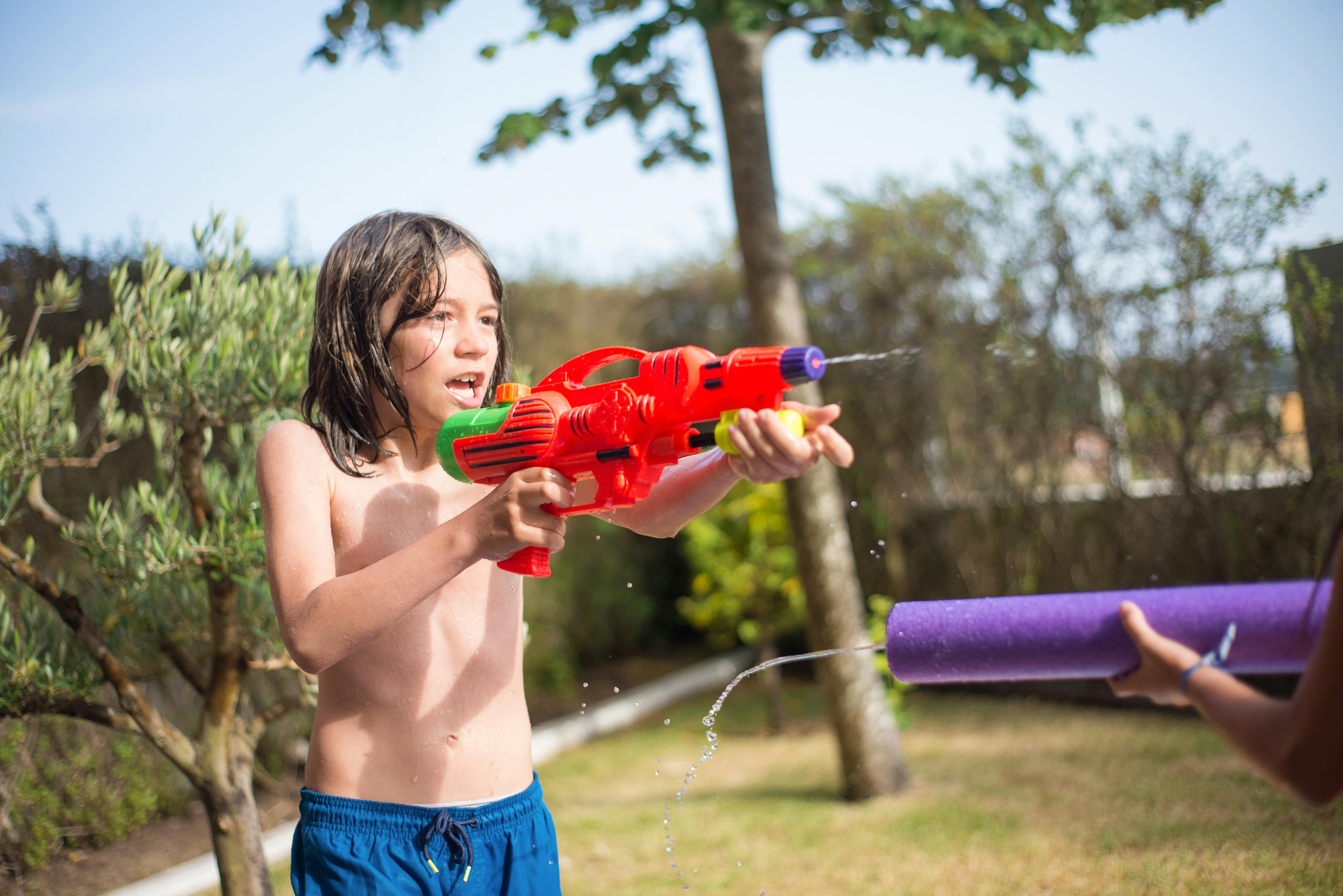 A boy playing with a water gun | Source: Pexels