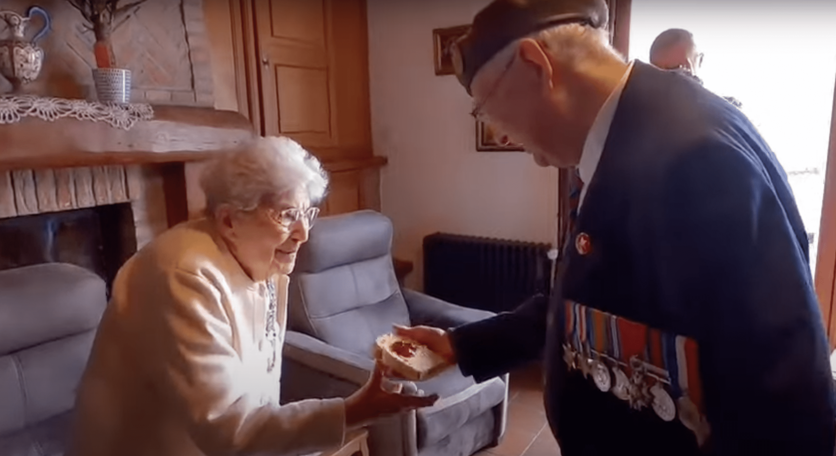 Reg Pye hands Huguette a slice of bread with jam. | Source: YouTube.com/Taxi Charity