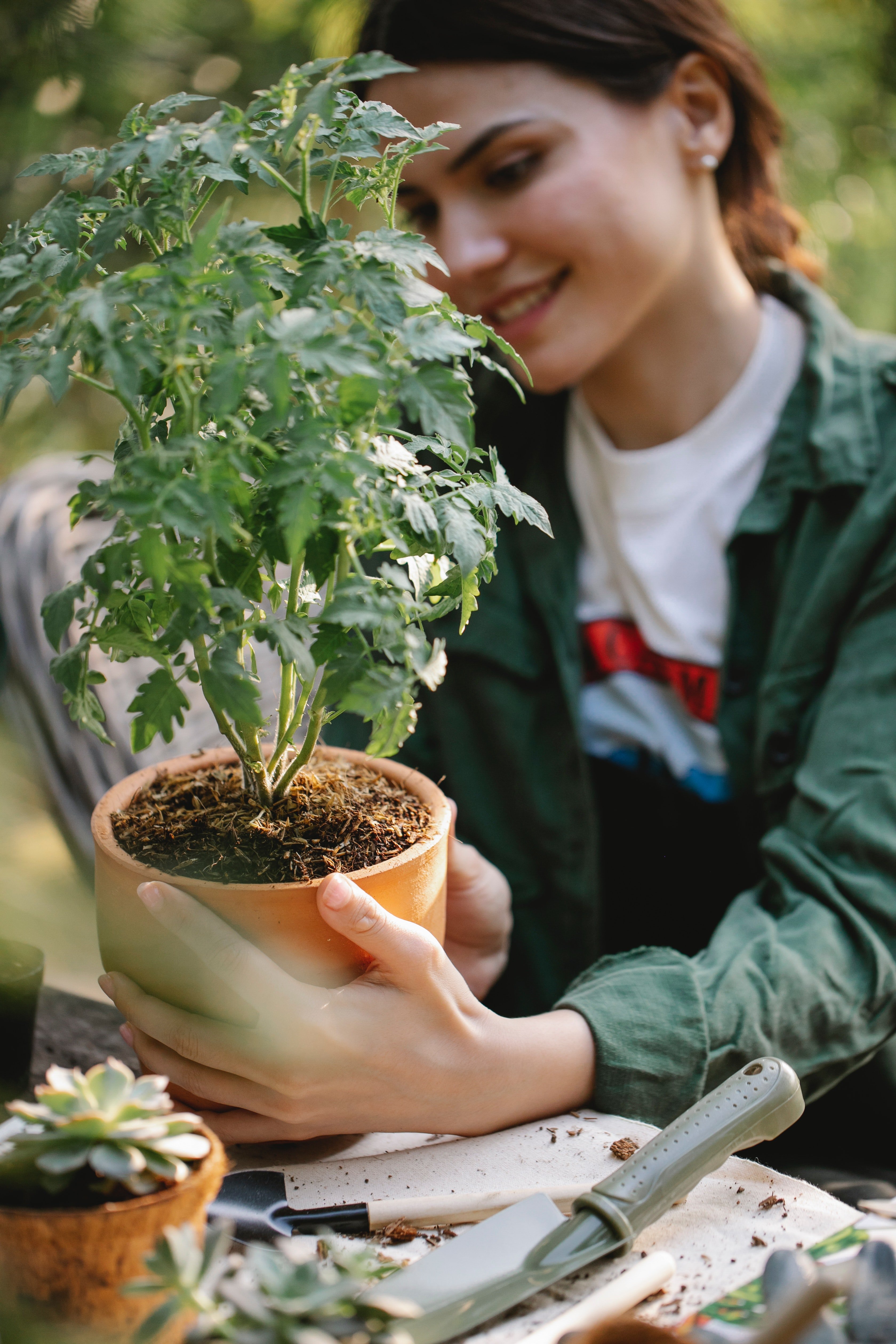 Joven mujer con una planta en sus manos. | Foto: Pexels