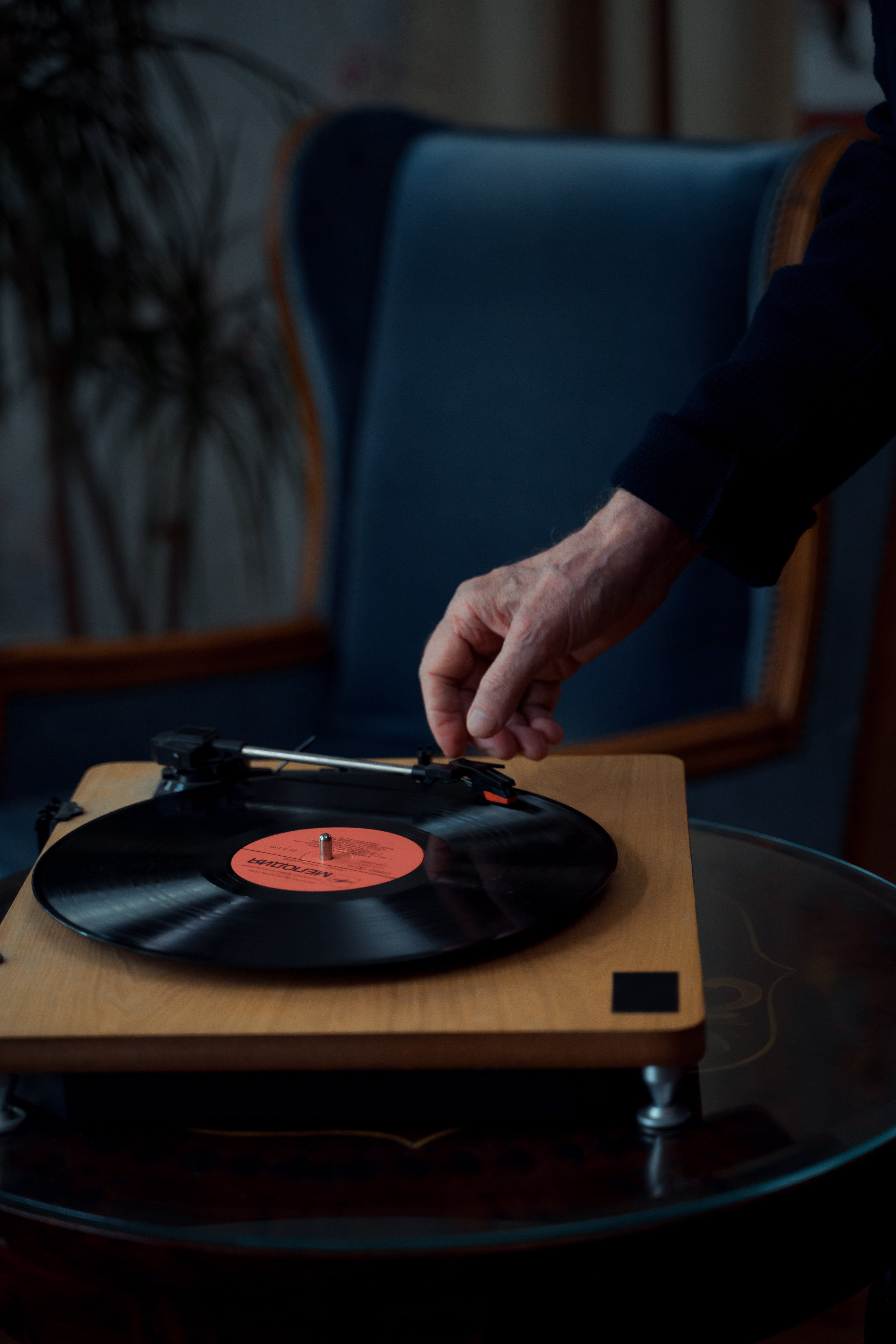 A person using a wooden phonograph player. | Source: Pexels