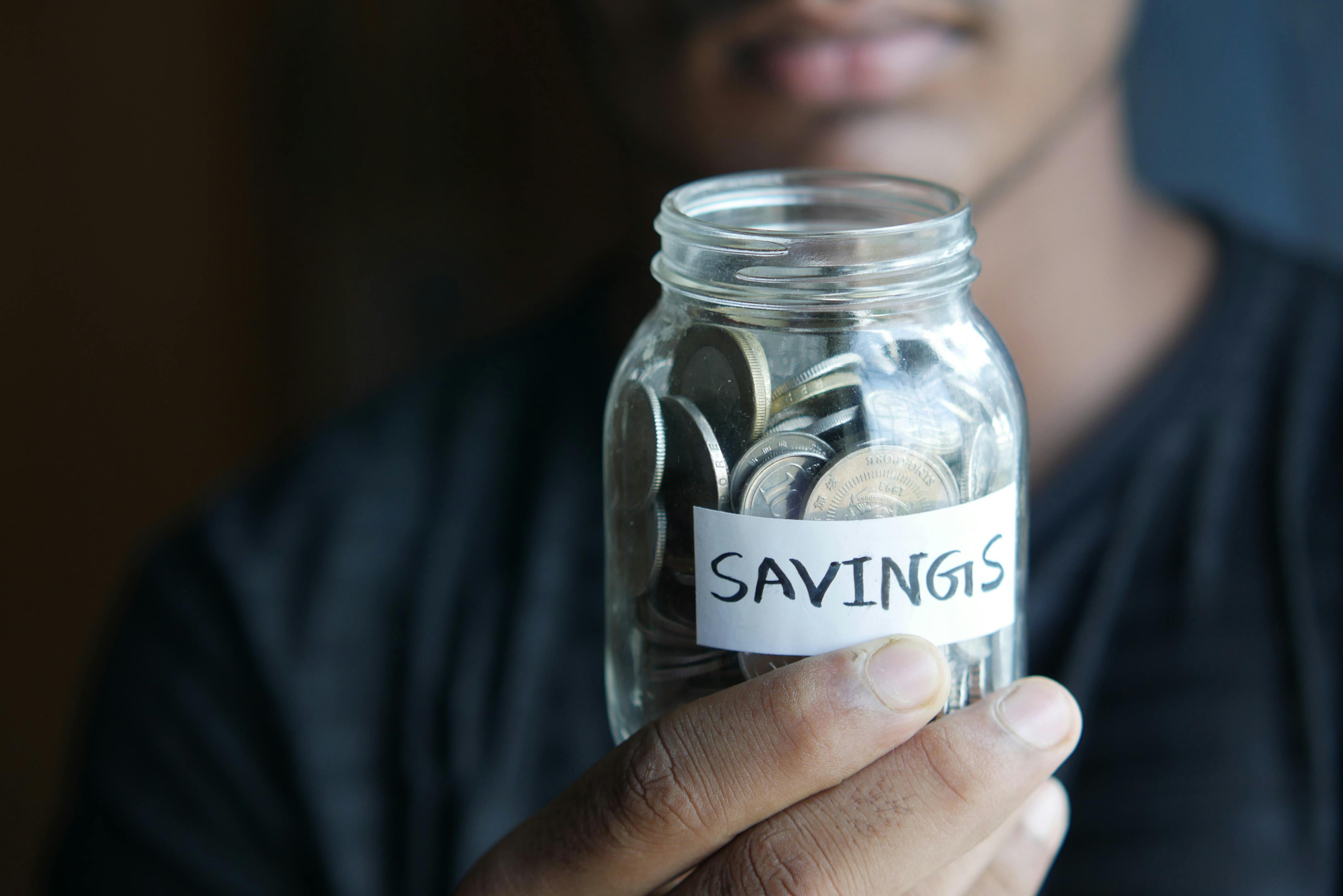 A person holding a savings jar with coins | Source: Pexels
