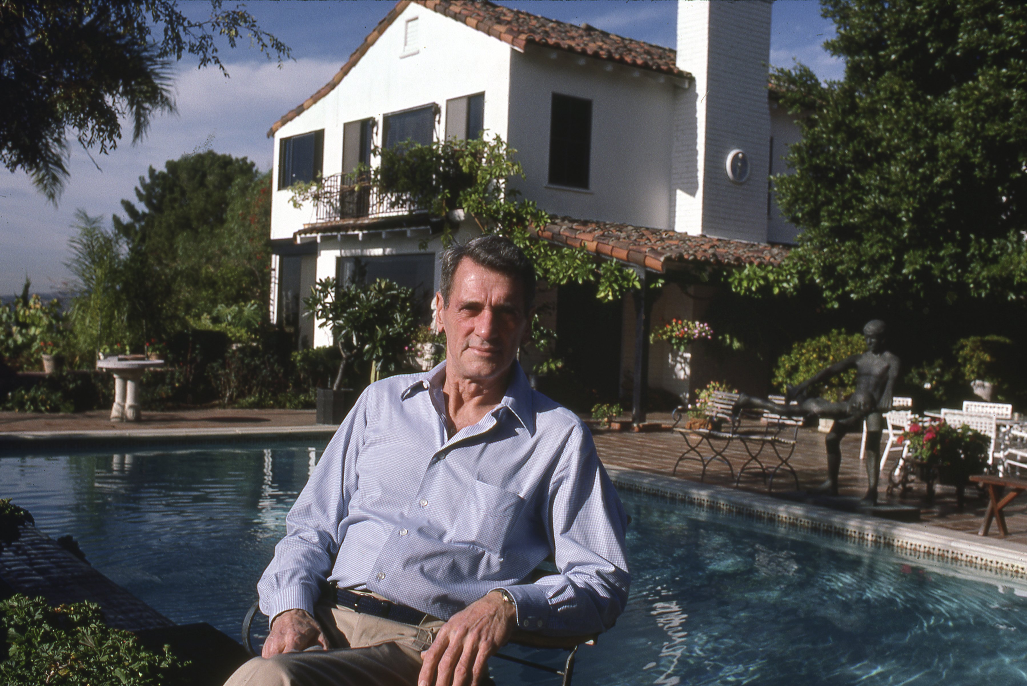 Rock Hudson relaxing by his pool in his Beverly Hills home in 1985 | Source: Getty Images